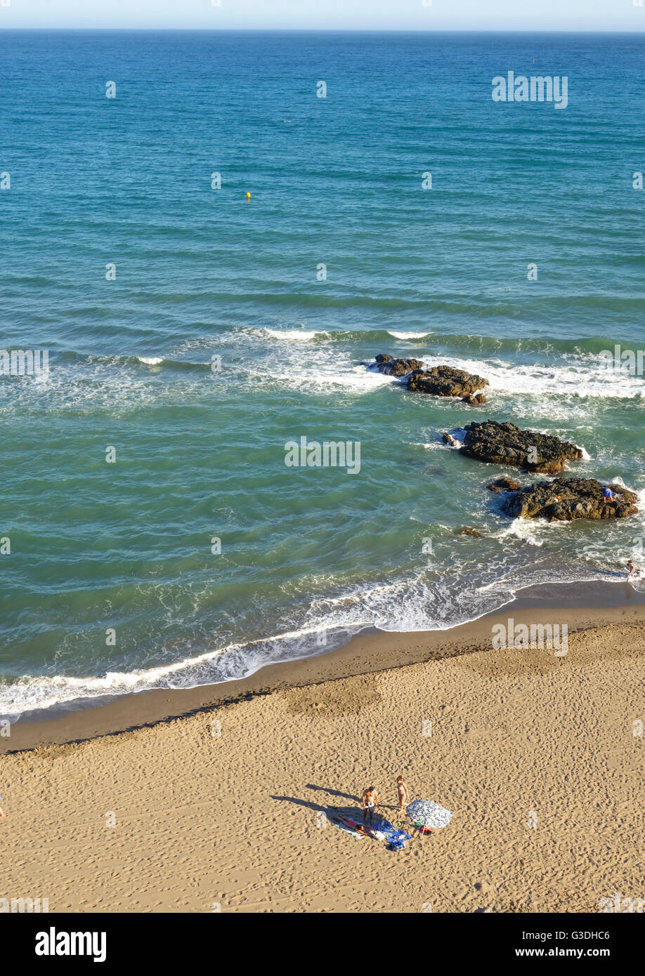 Luftaufnahme, junges Paar allein auf leeren Strand mit Sonnenschirm. Costa Del Sol, Spanien. Stockfoto