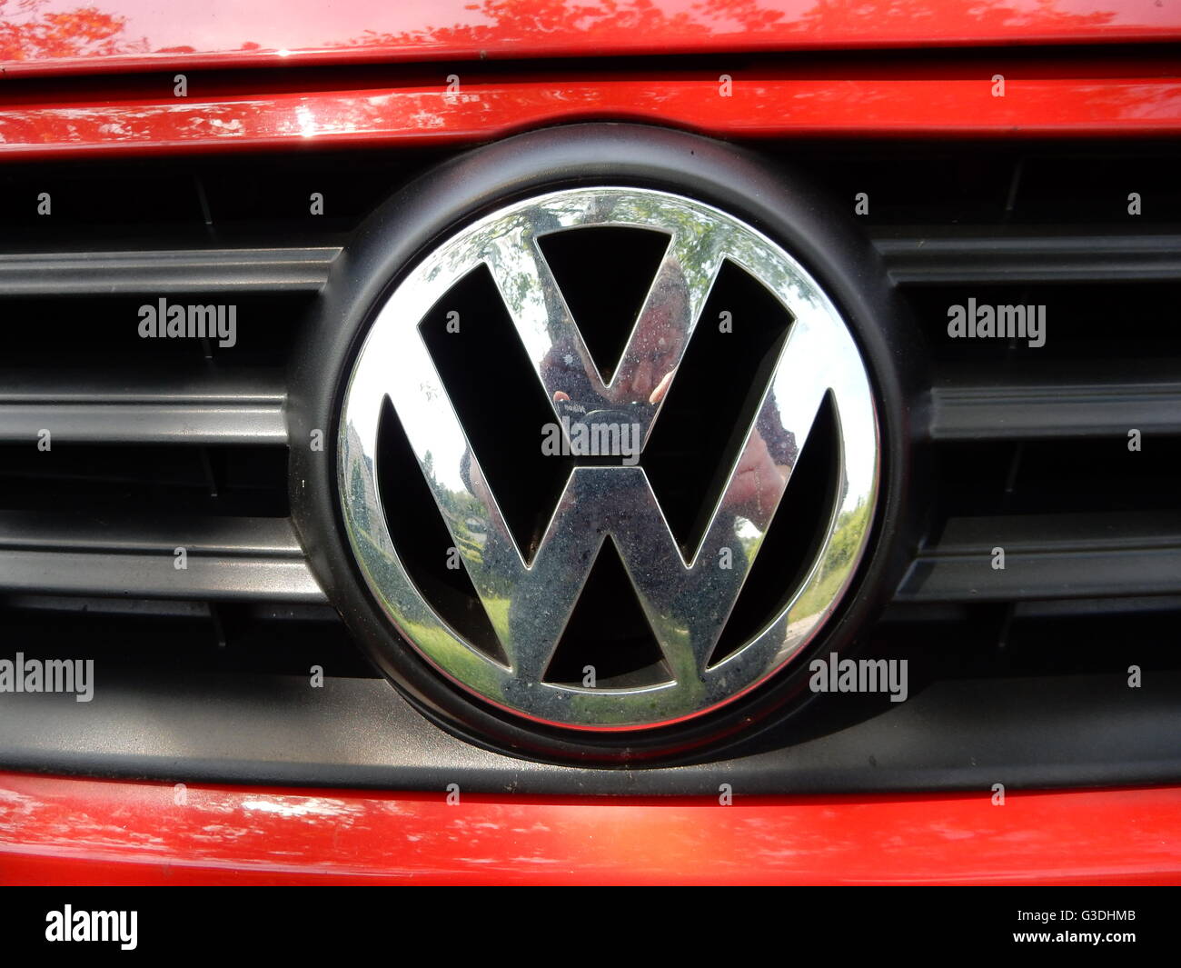 VW-Logo auf einem roten Volkswagen Auto Stockfoto