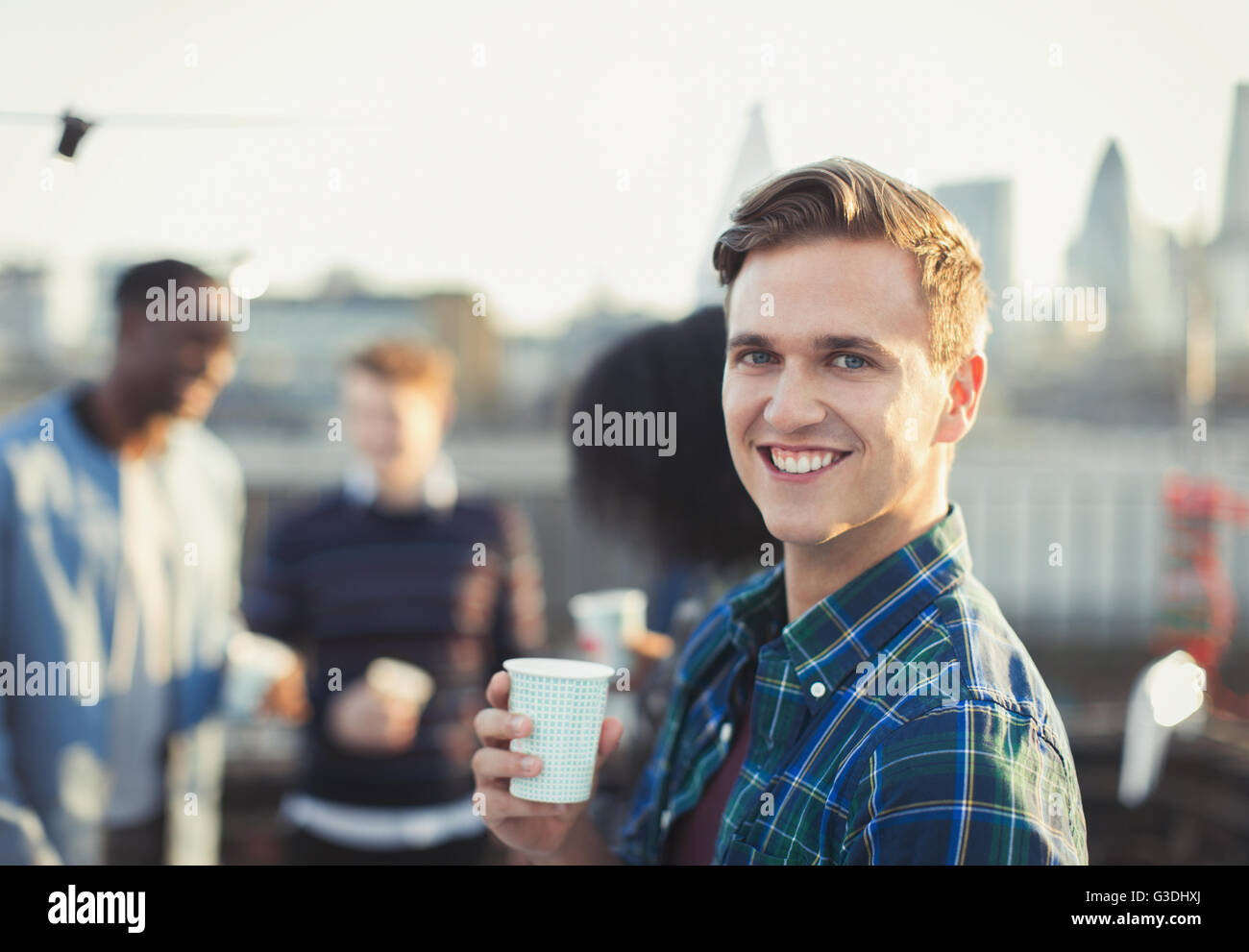Porträt, Lächeln jungen Mann trinken auf Party auf dem Dach Stockfoto