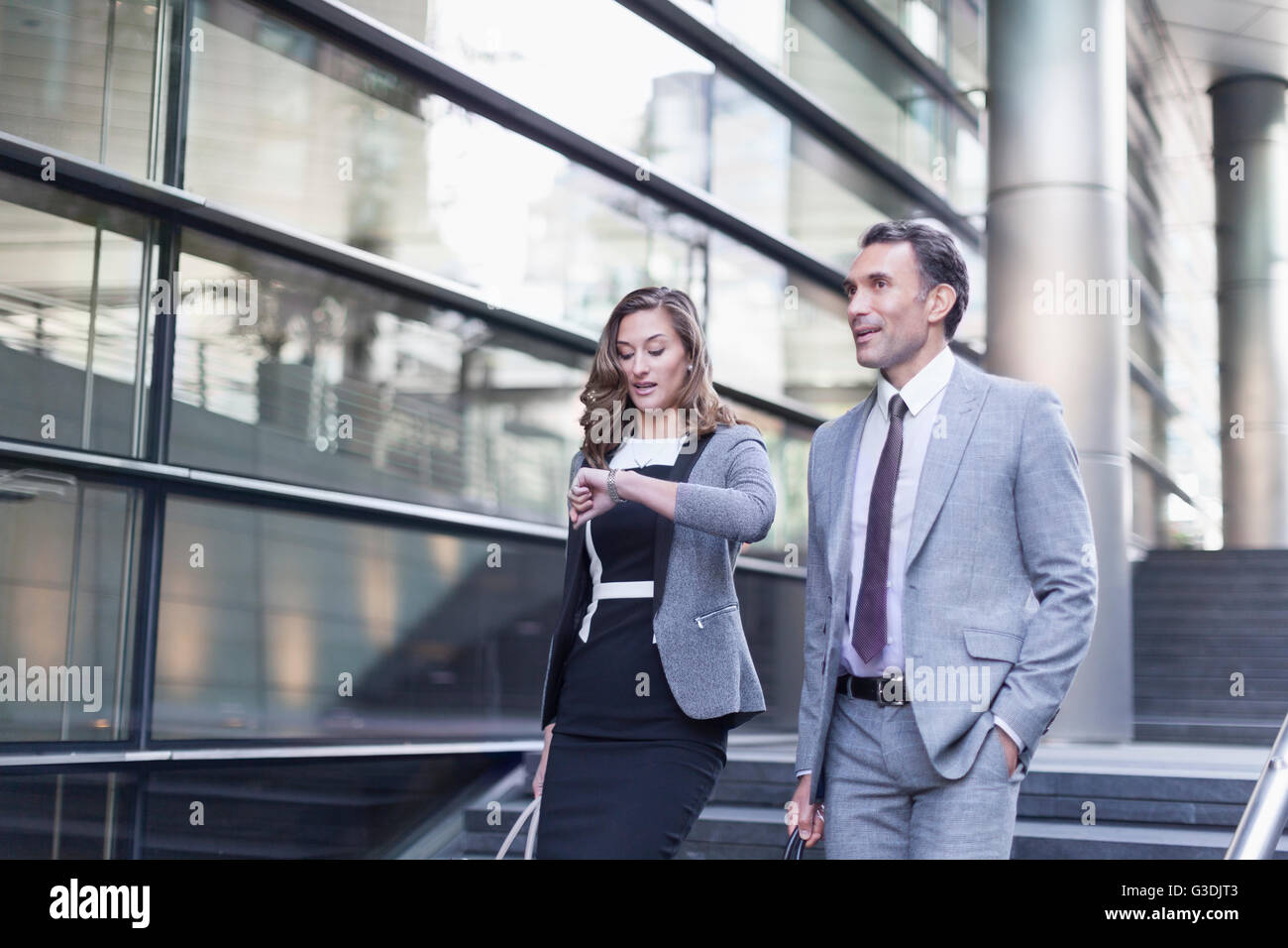 Corporate Geschäftsfrau Überprüfung Armbanduhr vor modernen Gebäude Stockfoto