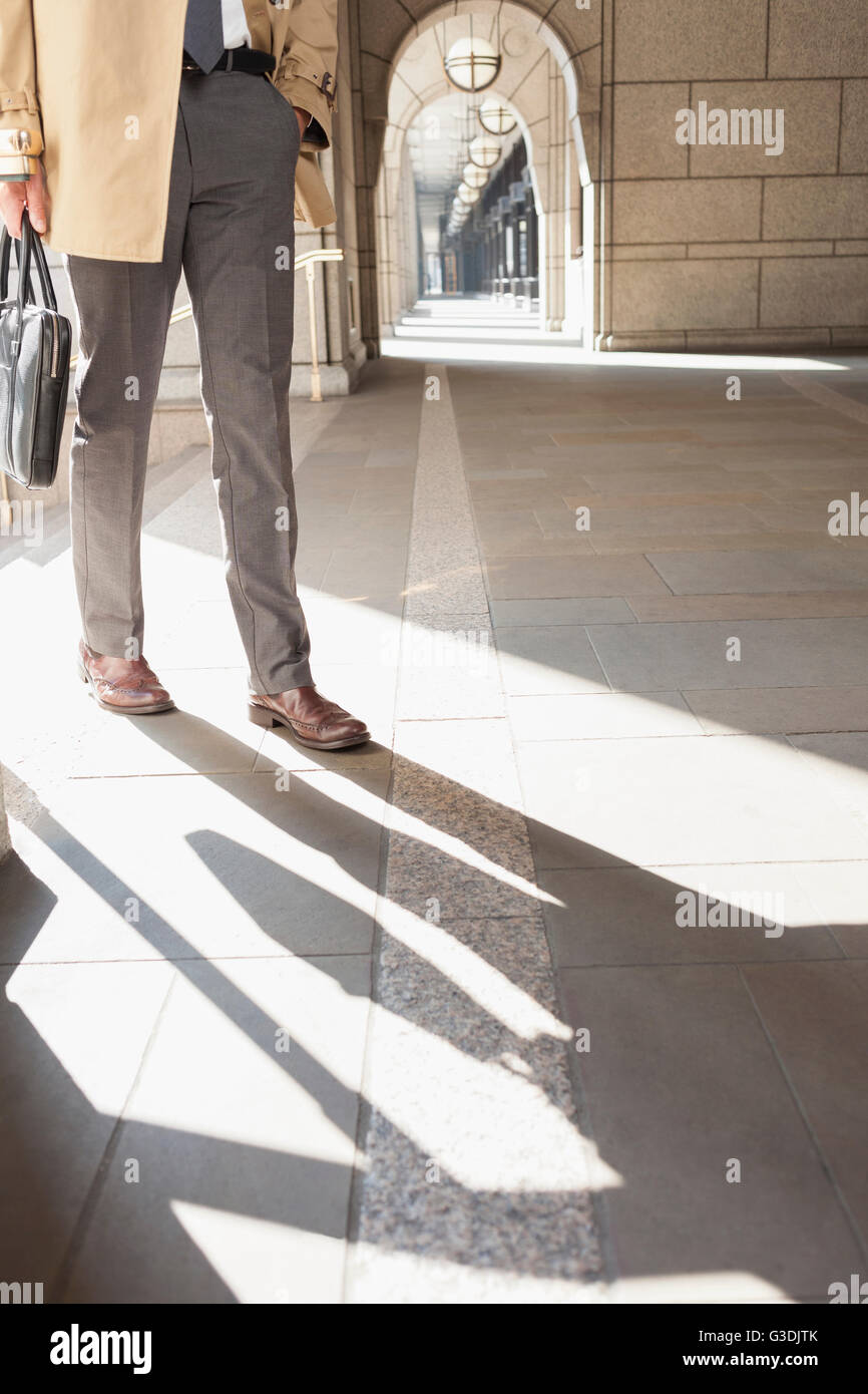 Corporate Geschäftsmann Wandern im sonnigen Kreuzgang Stockfoto