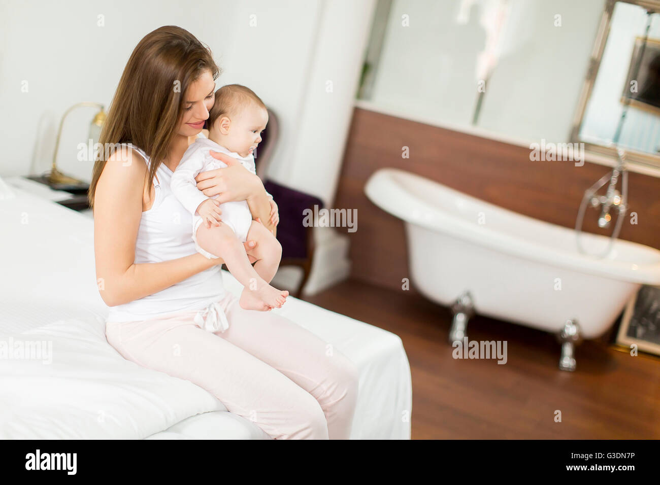 Glückliche Mutter mit Baby im Bett Stockfoto