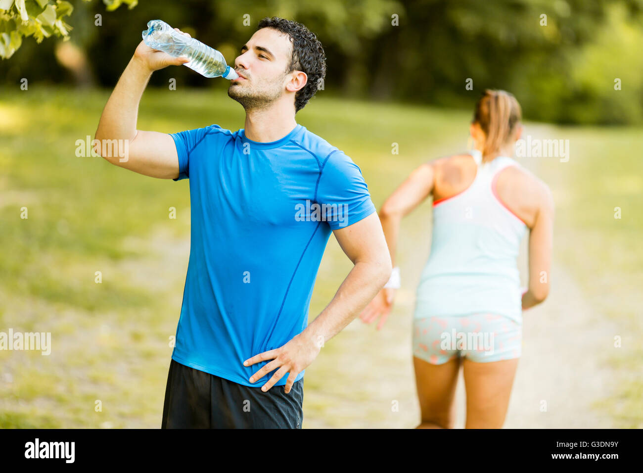 Athletische Sportart Man Trinkwasser aus der Flasche Stockfoto