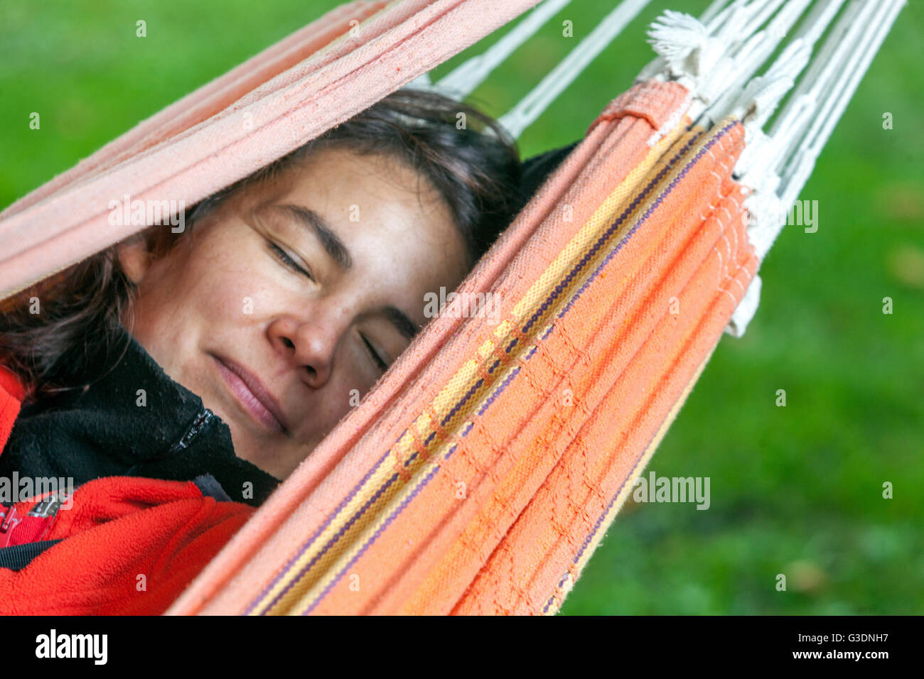 Porträt einer Frau, die in einem Hängemattengarten schläft und träumt Stockfoto