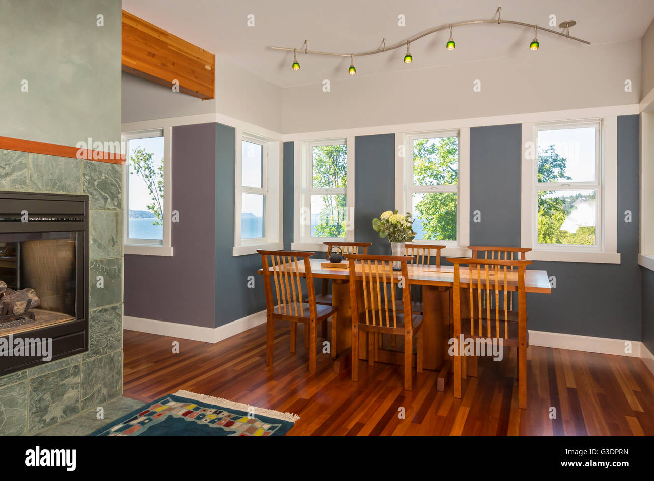 Bereich Esstisch & Stühle mit Holzböden, gestrichene Wände, Akzentbeleuchtung & Windows in zeitgenössische gehobene Wohngebäude anzeigen Stockfoto