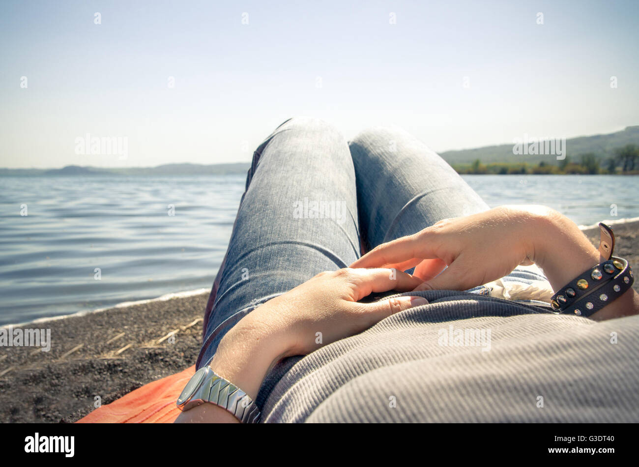 Frau entspannen liegen am Ufer Sees - erste Personenansicht Stockfoto