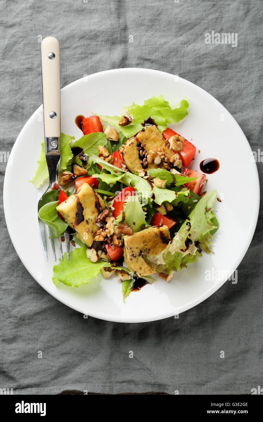 Salat mit gebratenem Tofu und Erdbeeren auf Teller Stockfoto
