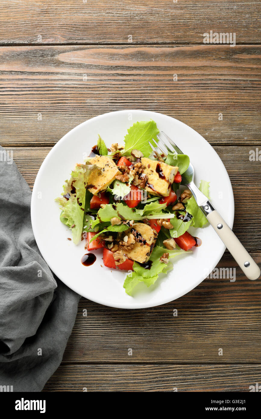 Salat mit Tofu und frischen Erdbeeren auf Holztisch Stockfoto
