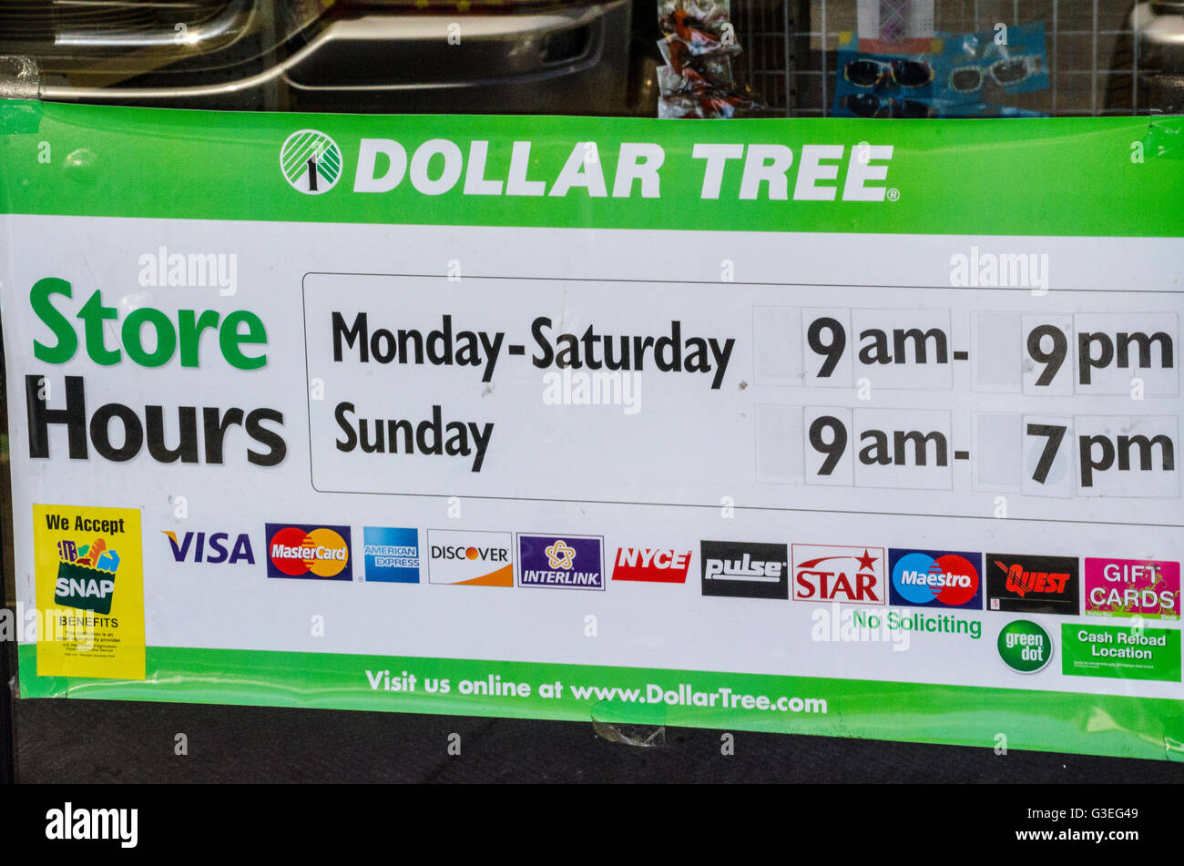 Ein Schild an einen Baum Discounter mit Öffnungszeiten und Zahlungsarten akzeptiert. Stockfoto