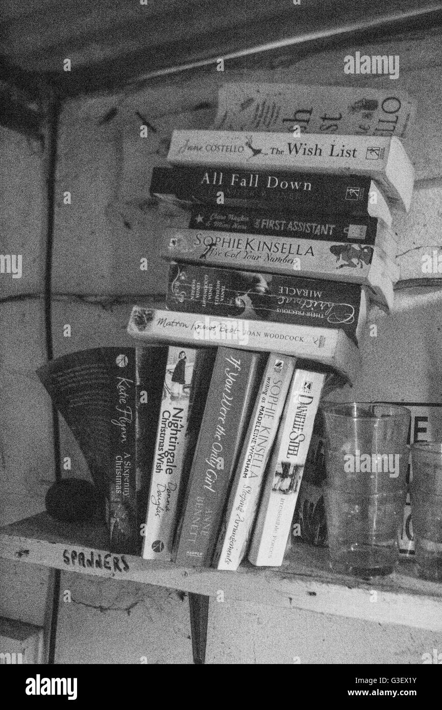 Haufen von alten Taschenbücher auf einem Regal Stockfoto
