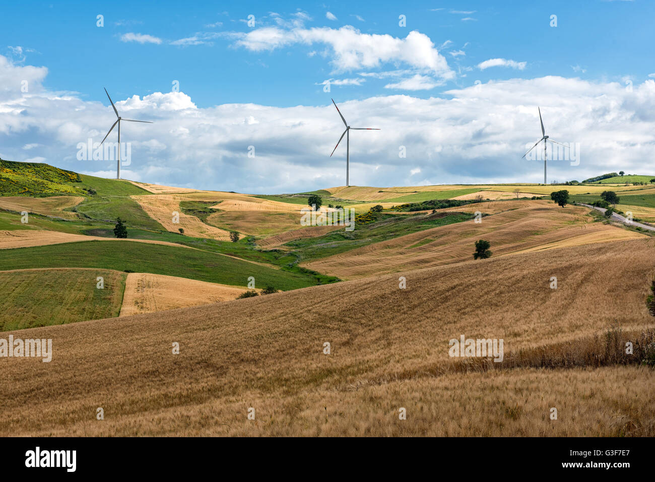 Reihe von Windenergieanlagen in einen Windpark auf den Hügeln über sanfte Agrarland in ein Konzept der alternativen Energie betrachtet eine Stockfoto