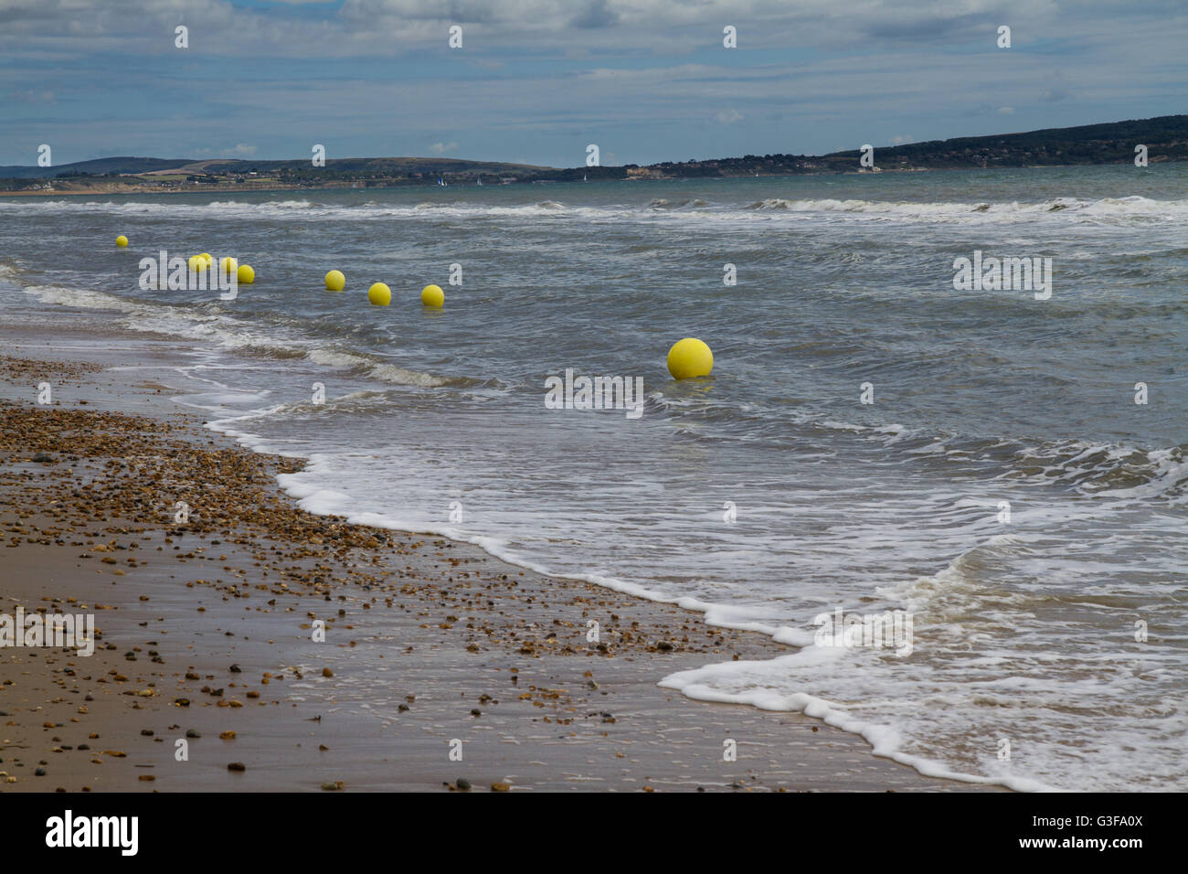 UK-Kiesstrand mit gelben Bojen. Stockfoto