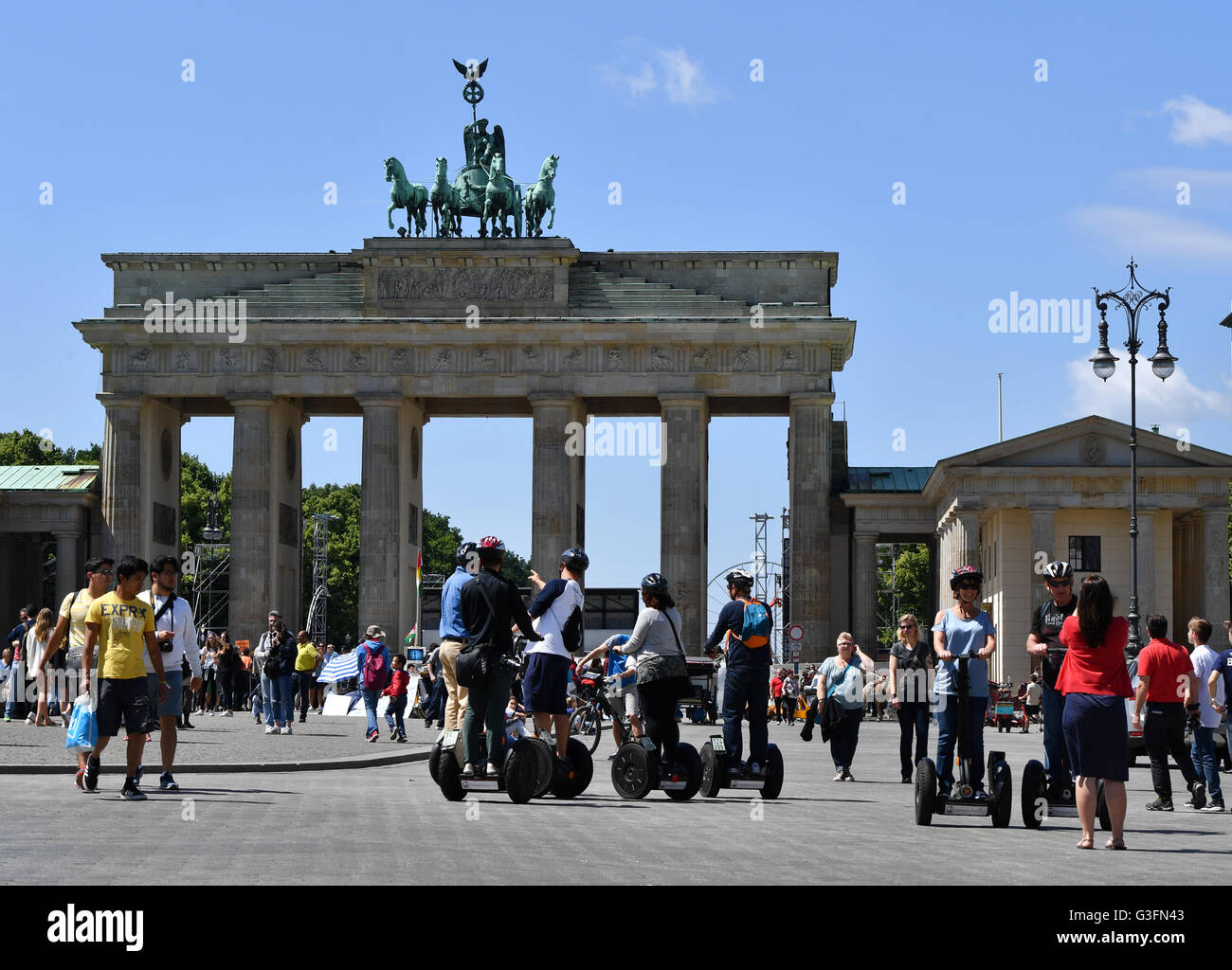 Touristen auf Segways neben Fußgängern am Brandenburger Tor in Berlin, Deutschland, 10. Juni 2016. Foto: JENS KALAENE/dpa Stockfoto