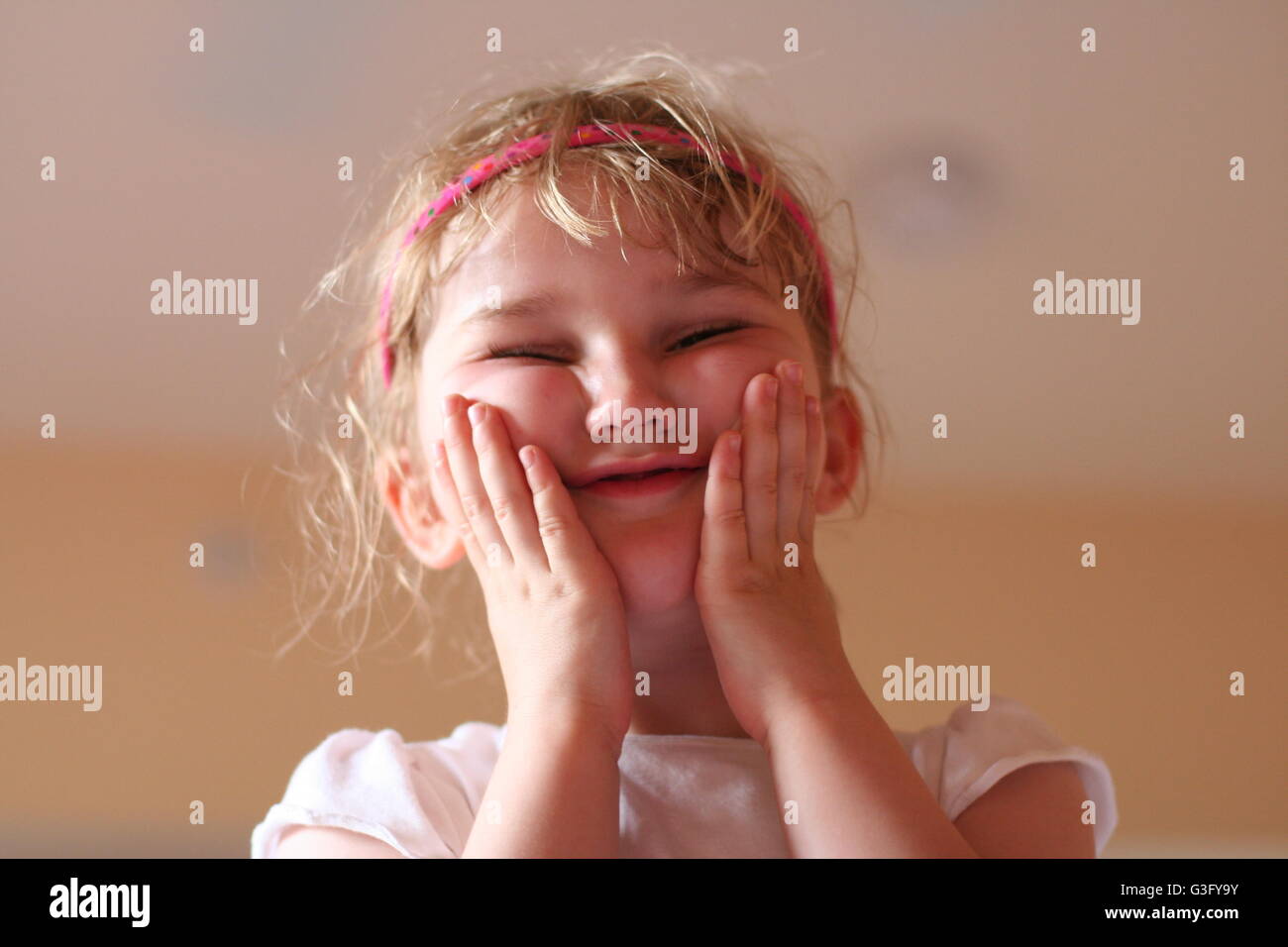 Blonde Mädchen Kind Spaß spielen und Messing, ein lustiges Gesicht lustige Geste, ein Gesicht, Grimassen Kindheit moment, Konzept Stockfoto