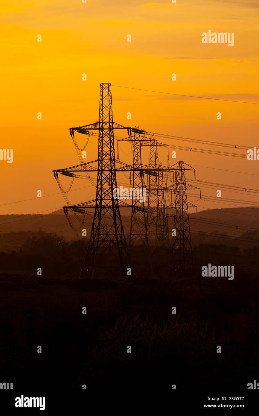 Silhouetted Stromleitungen oder Masten auf halkyn Mountain Transport von elektrischer Energie über North Wales, Großbritannien Stockfoto