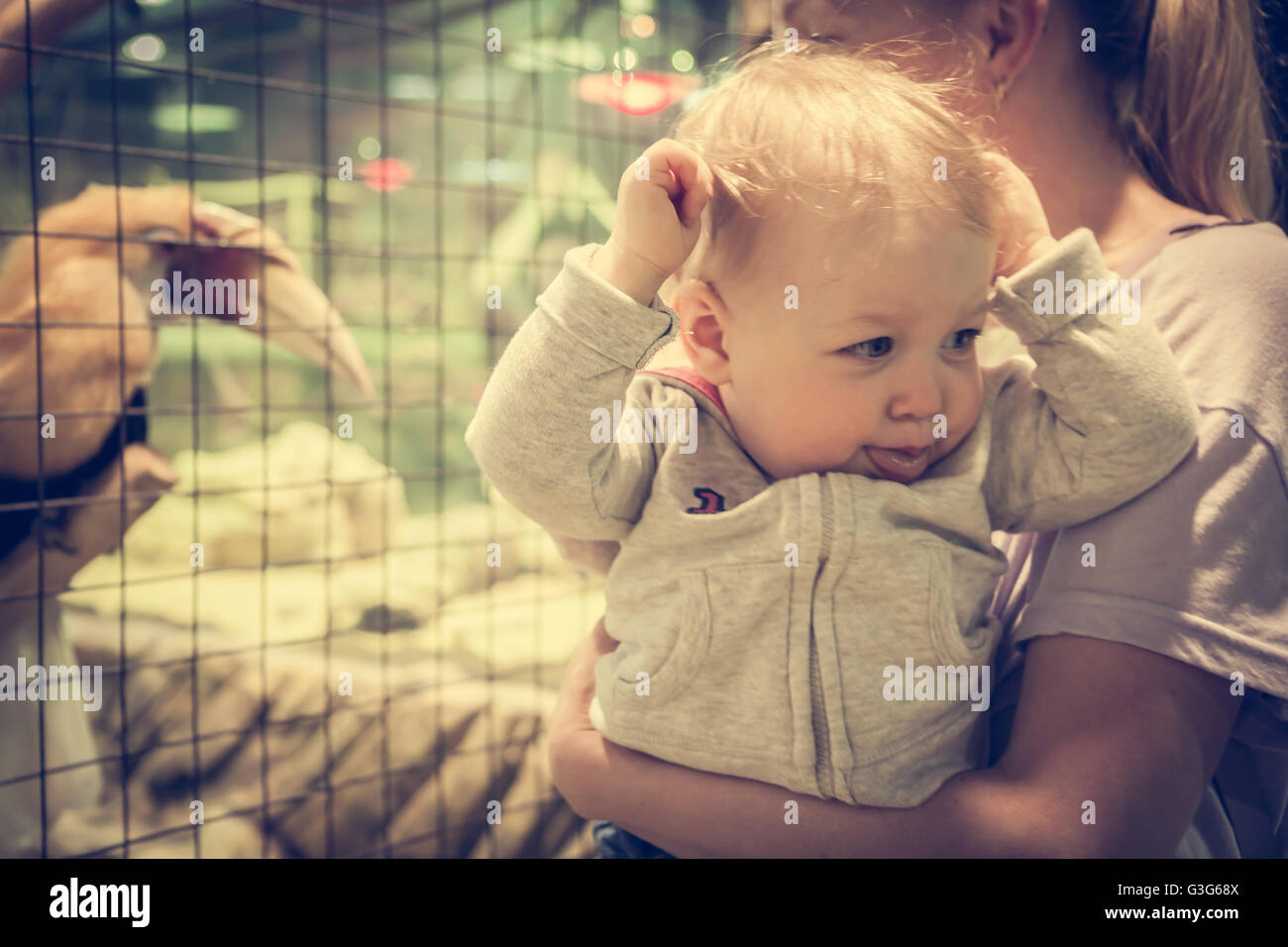 Lustige Baby mit Mutter machen Gesichter im Zoo begeistert Stockfoto