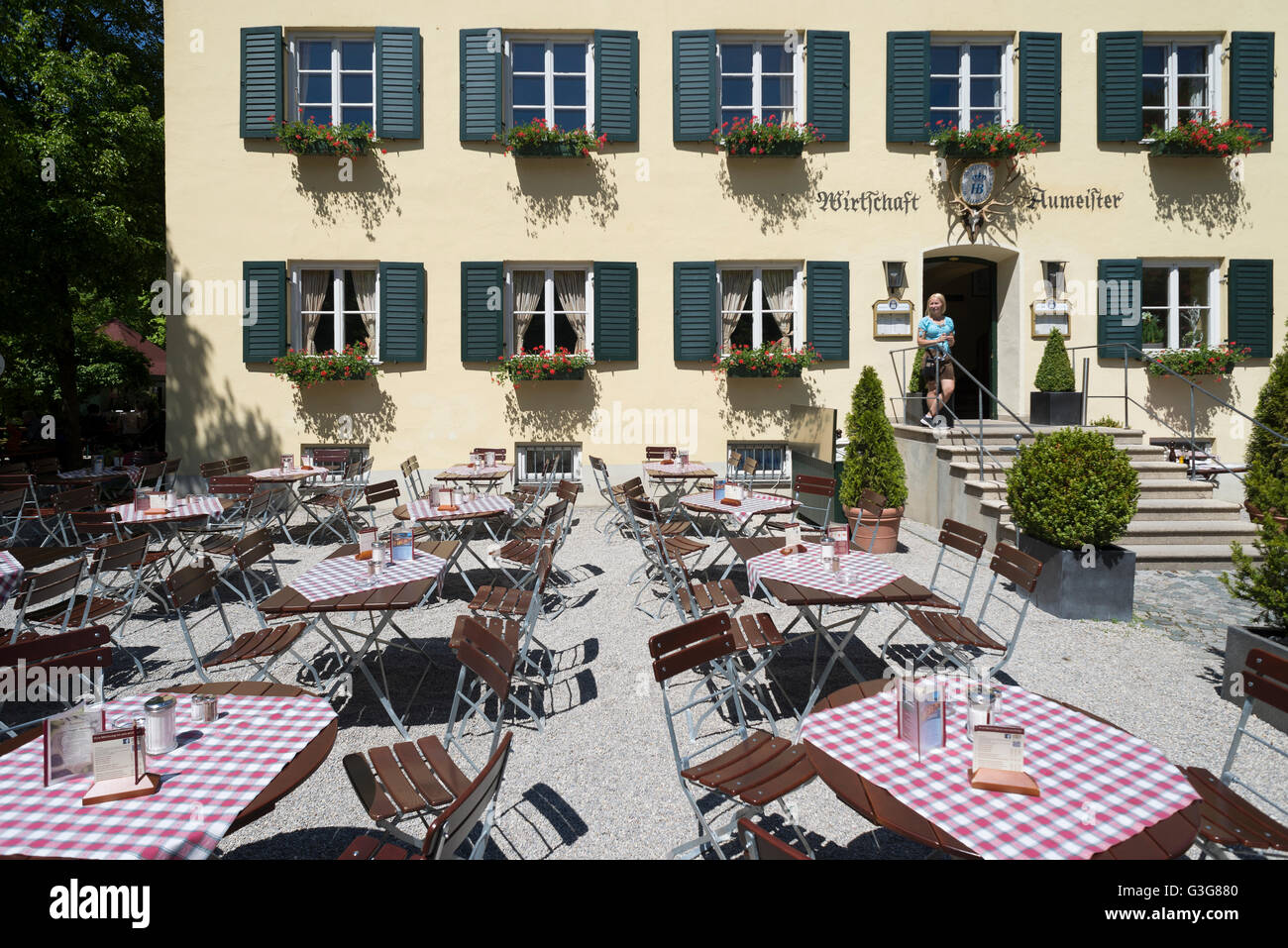 Tische, Stühle und eine Kellnerin vor der Fassade des Restaurant Aumeister im englischen Garten in München, Bayern, Deutschland Stockfoto