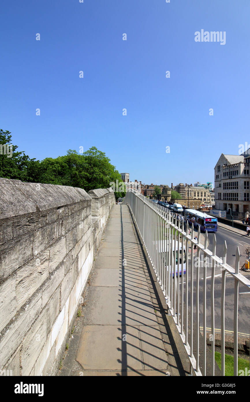Der Blick auf das Münster entlang der alten steinernen Mauern der historischen Stadt York an einem schönen Sommertag. Stockfoto