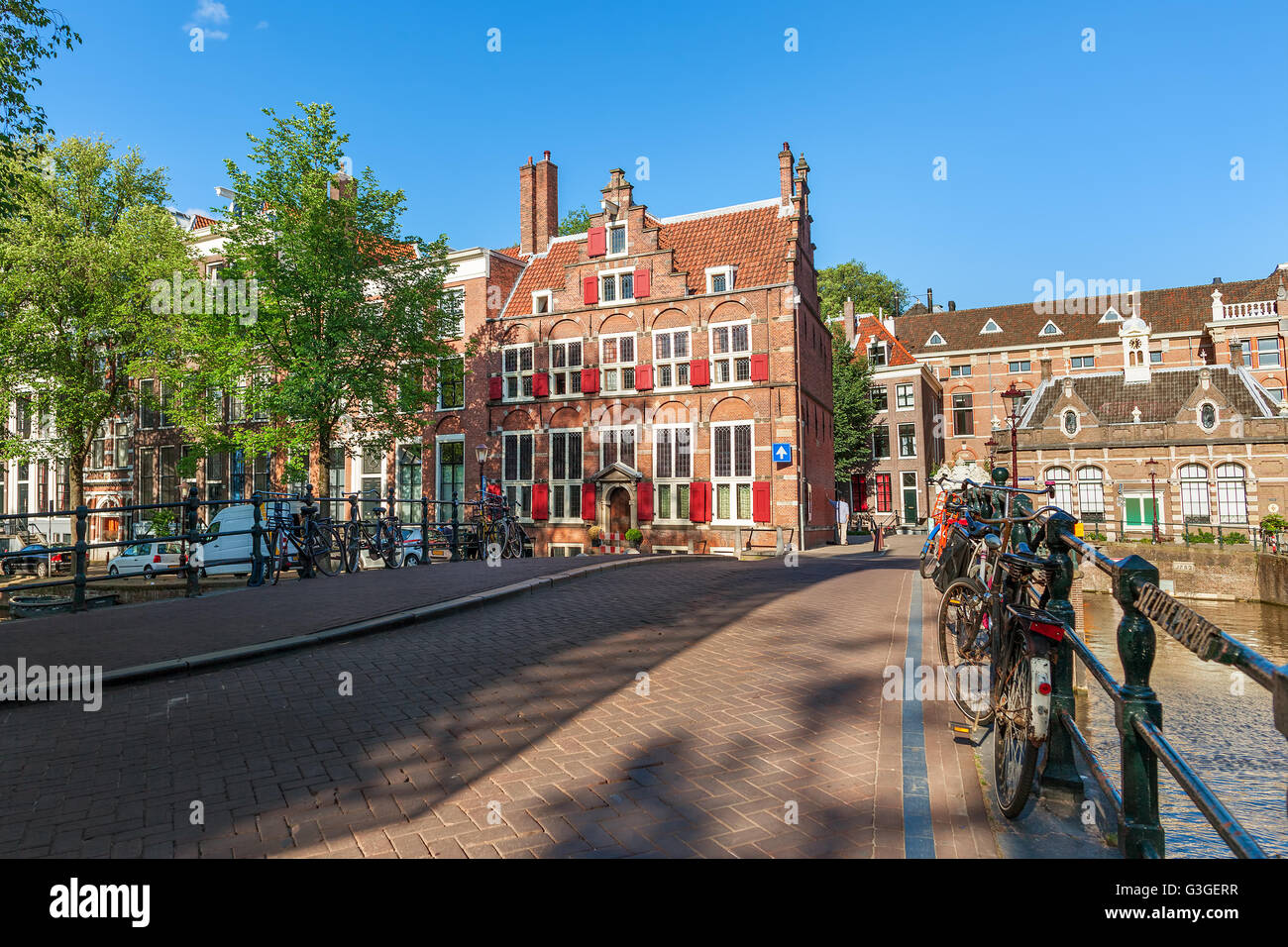 Fahrräder auf der kleinen Brücke über den Kanal und typische Architektur auf Hintergrund in Amsterdam, Niederlande. Stockfoto