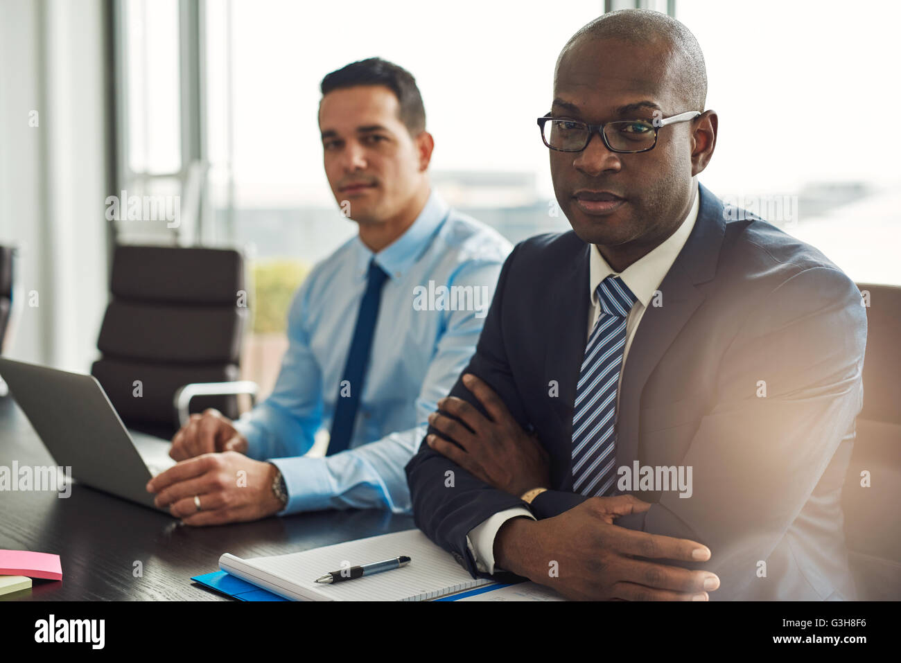 Erfolgreichen gemischtrassigen Geschäftspartner bei einem Treffen mit junger Hispanic Mann mit einem Laptop und afroamerikanische Mann Stockfoto