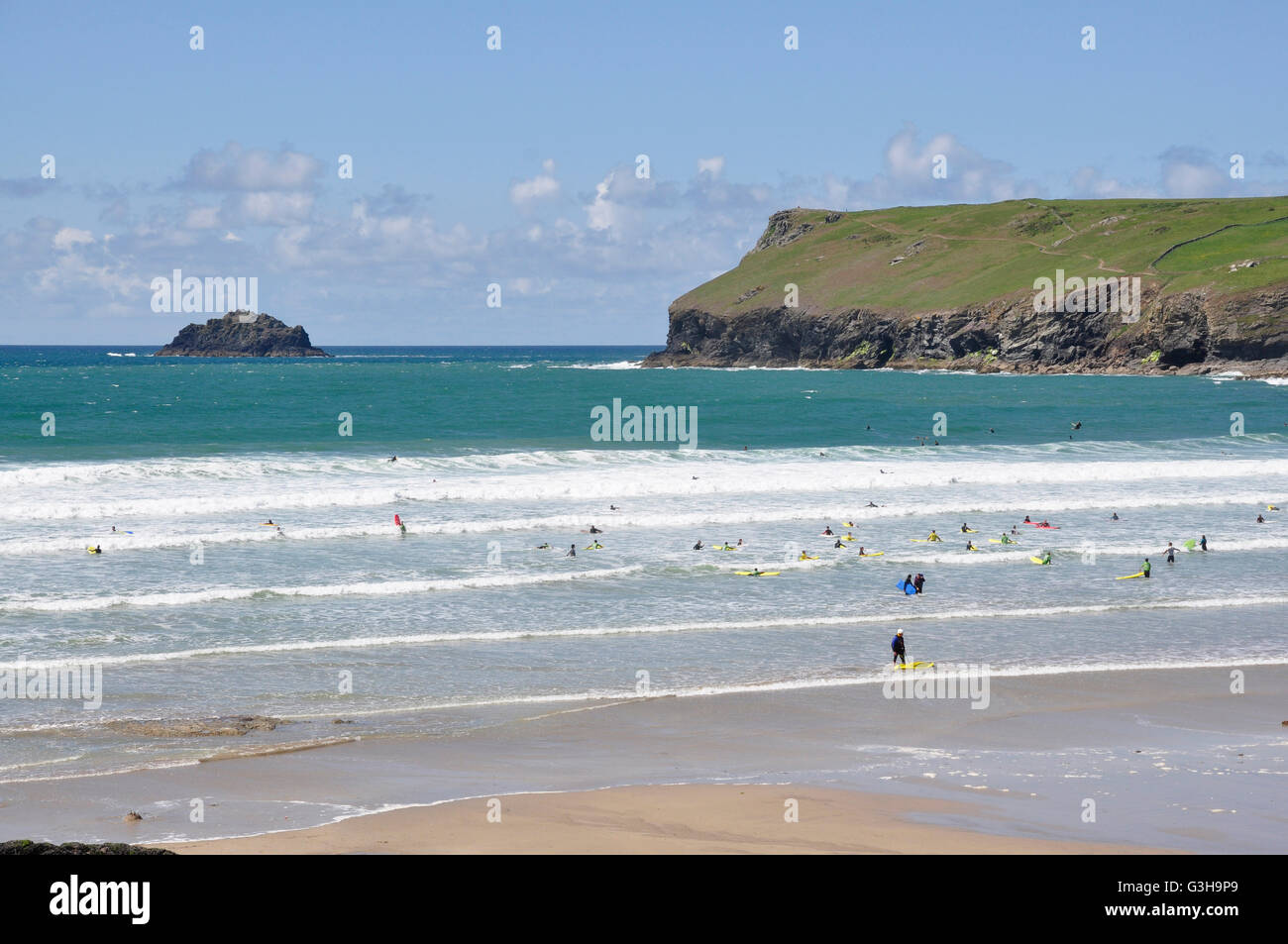 Polzeath Strand - eingehende Flut - weiße Spitze Rollen - Surfer - blaues Meer und Himmel - Kulisse Pentire Kopf Cornwall Stockfoto