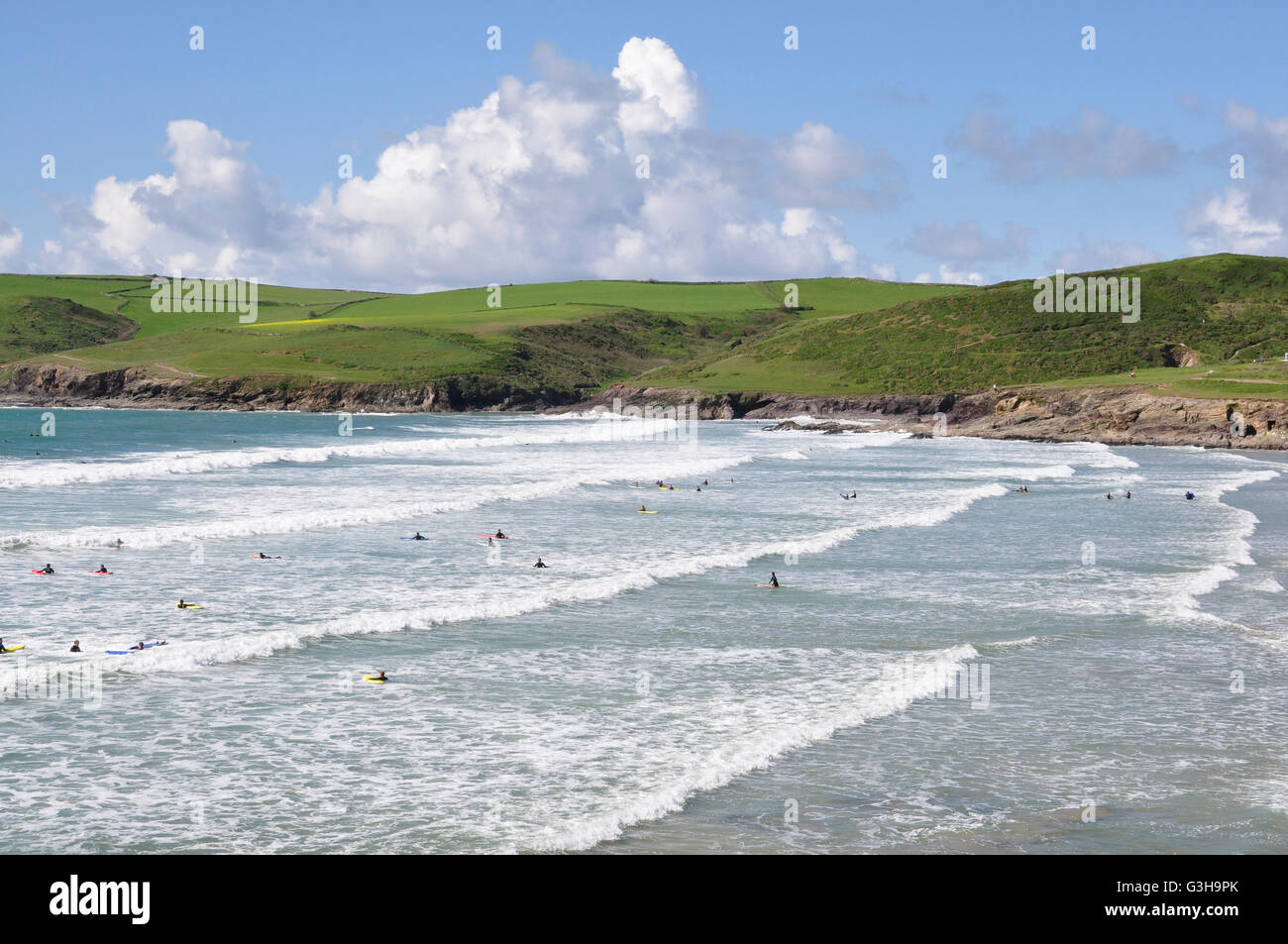 Cornwall - Polzeath Strand - weiß gekappt, Rollen - Surfer - Kulisse Pentire Kopf - blauen Meer und Himmel hell Sommersonnenschein Stockfoto