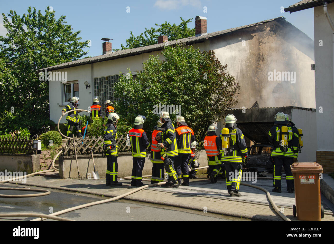 Feuerwehrleute Löschen einer brennenden garage Stockfoto