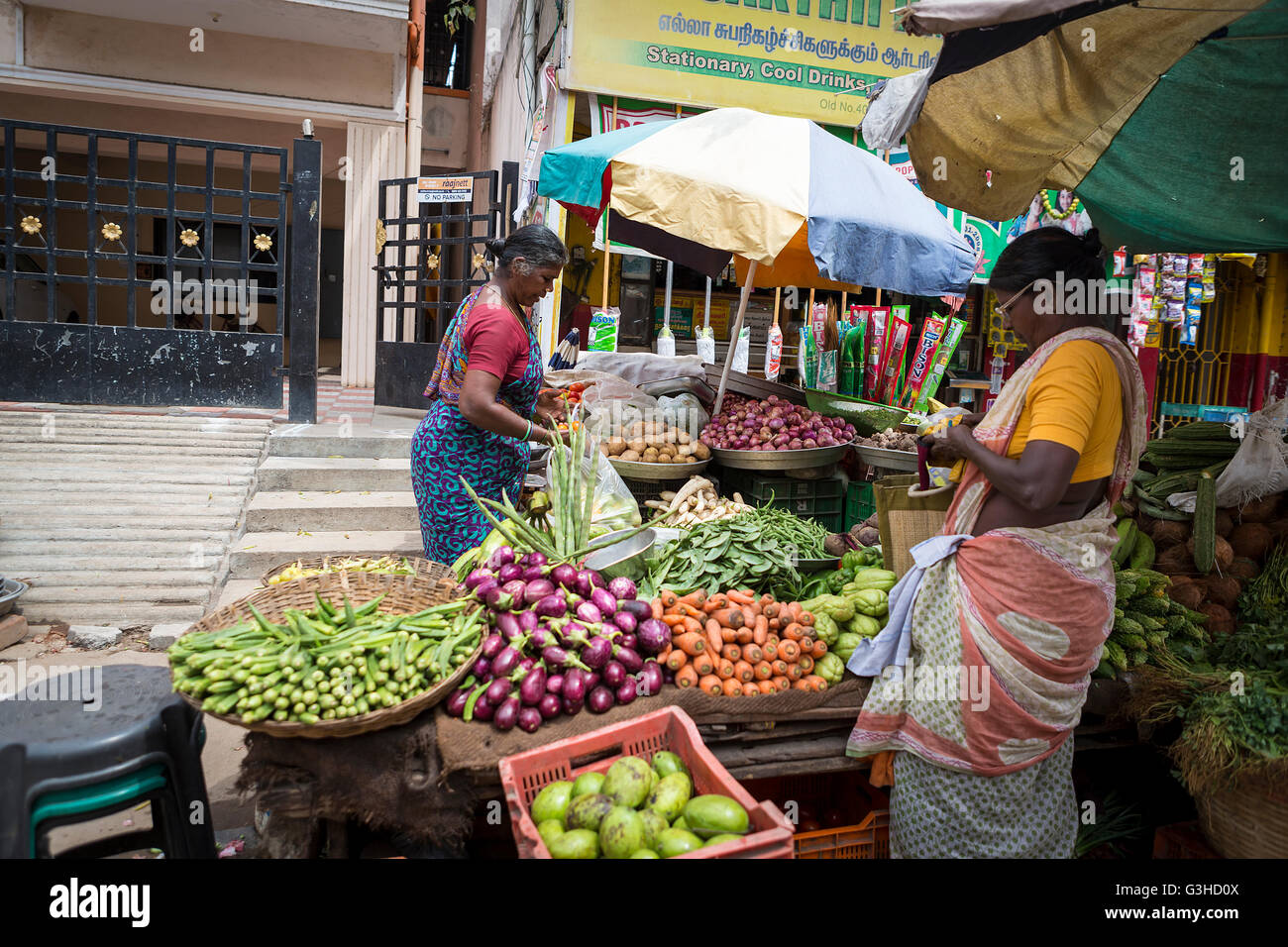 Eine Inderin kaufen und eine Dame verkaufen Obst und Gemüse auf einem Straßenstand in Mylapore, Chennai, Tamil Nadu, Indien, Asien Stockfoto