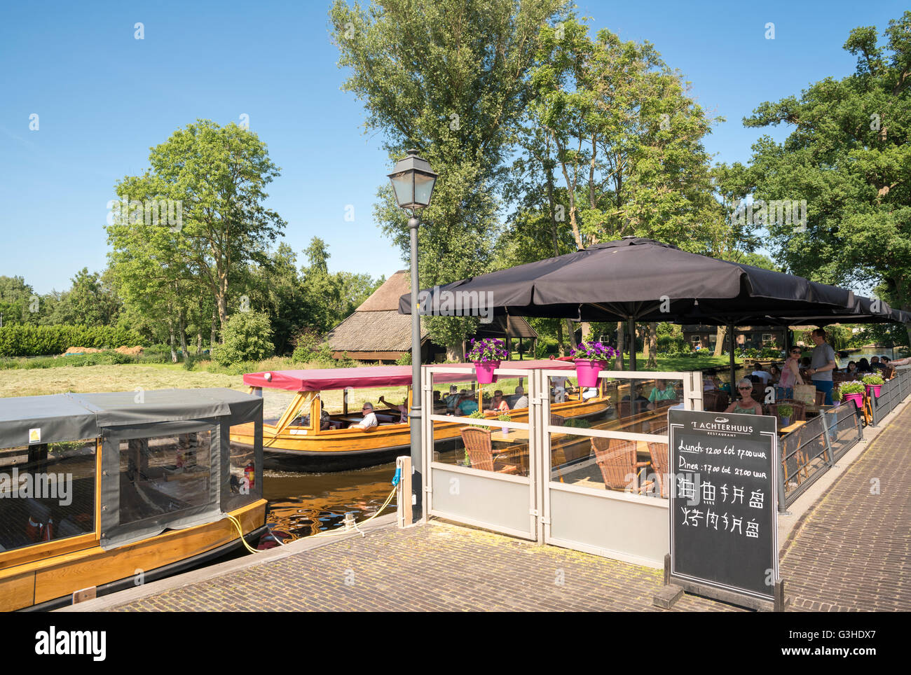 Giethoorn, Niederlande. Restaurant Terrasse ' t Achterhuus mit dem Kanalboot Tour führen. Melden Sie in Chinesisch für chinesische Touristen. Stockfoto