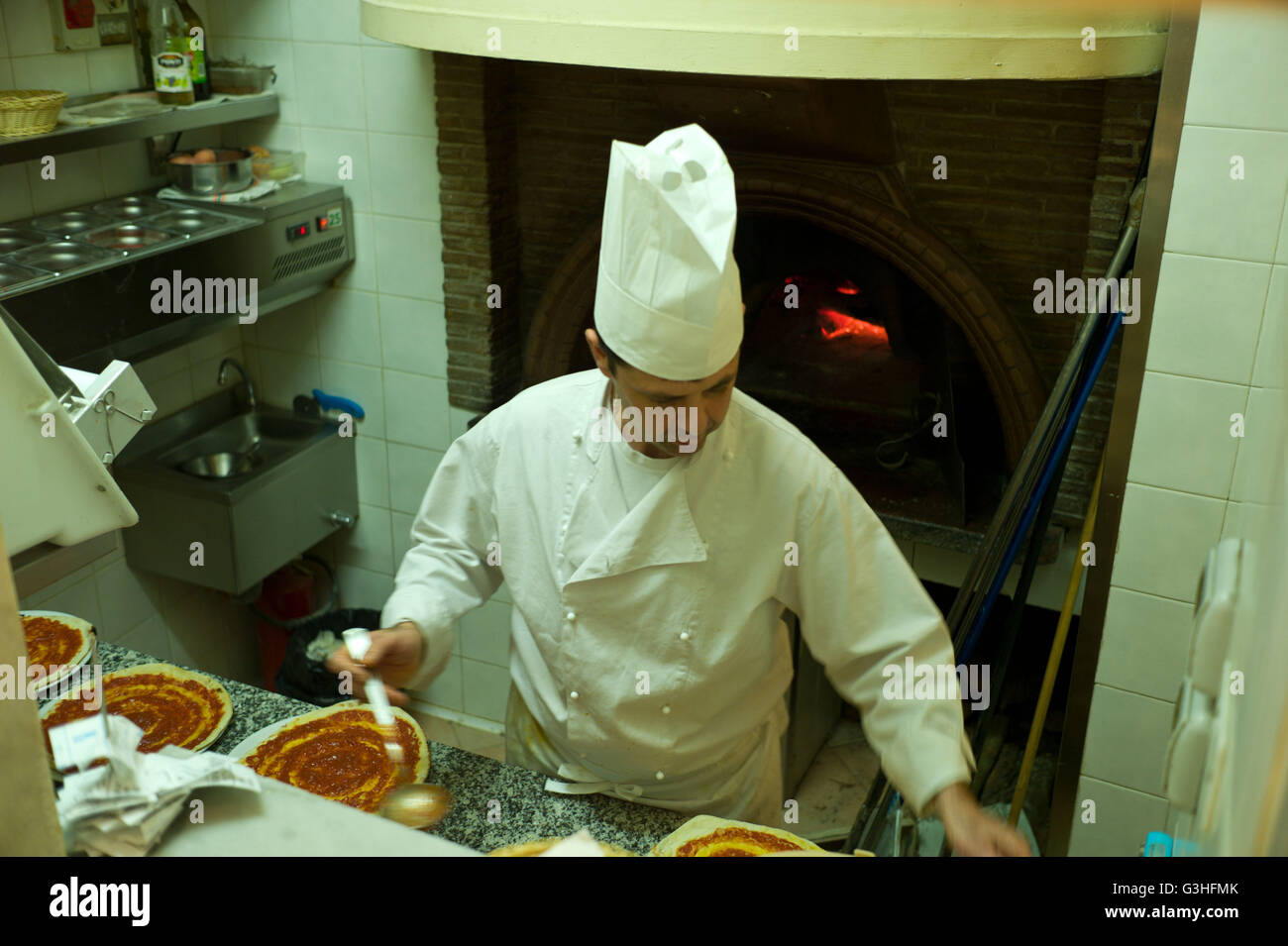 Koch, die Vorbereitung von Pizza in einem Restaurant vor dem Kochen in einem traditionellen Pizzaofen, Rom, Italien Stockfoto