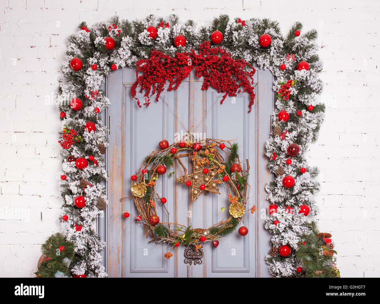 Weihnachten-Holztür mit Tanne zweigt eine Silvester-Dekoration. Stockfoto