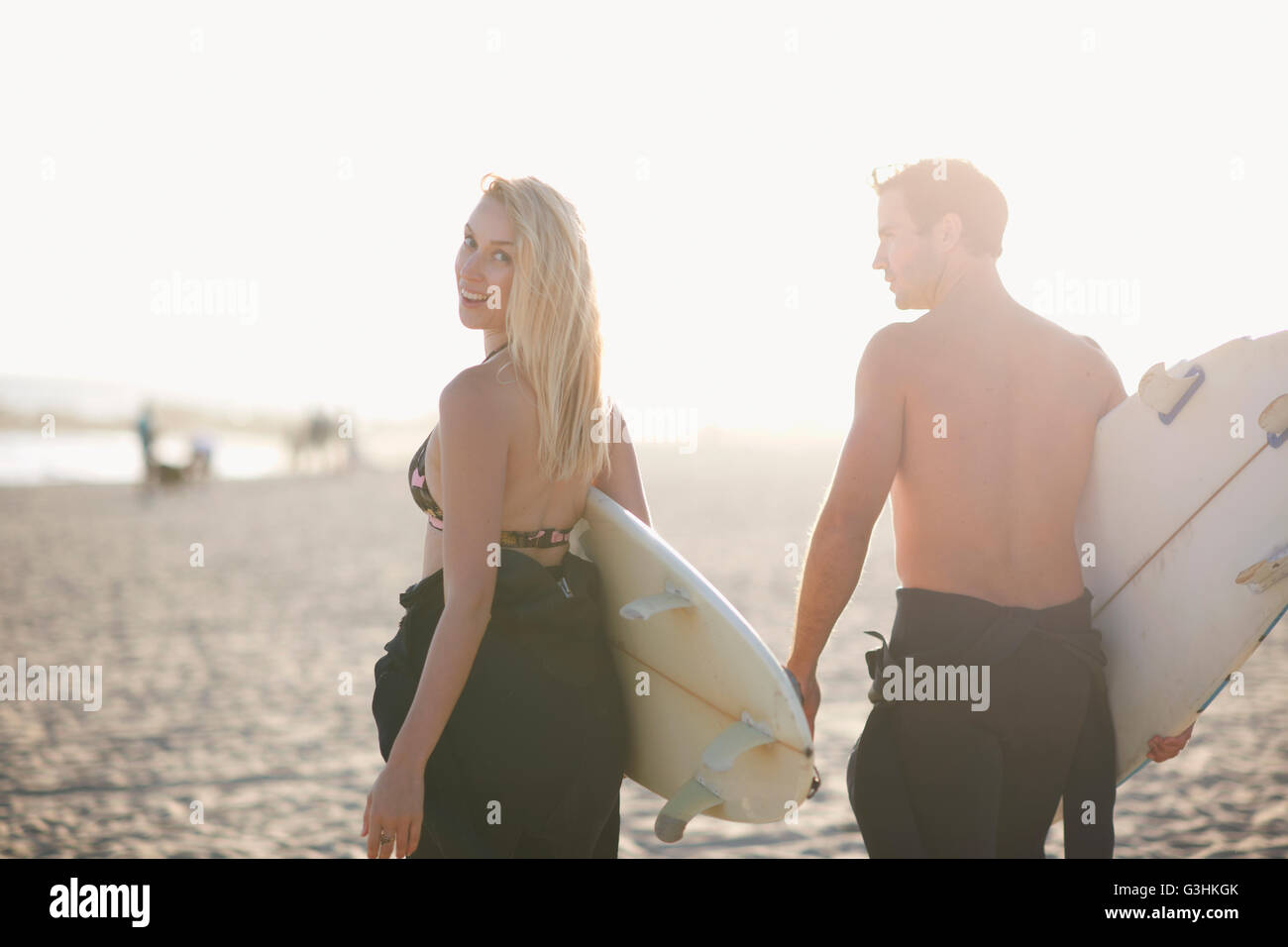 Surfen-paar mit Surfbrettern auf sonnenbeschienenen Venice Beach, Kalifornien, USA Stockfoto