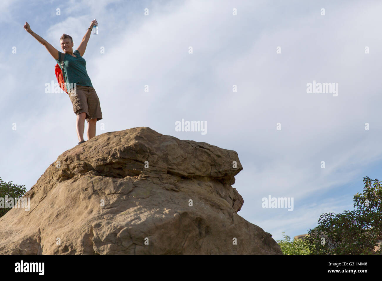 Frau Wanderer oben auf Felsen erhobenen Armen Stockfoto