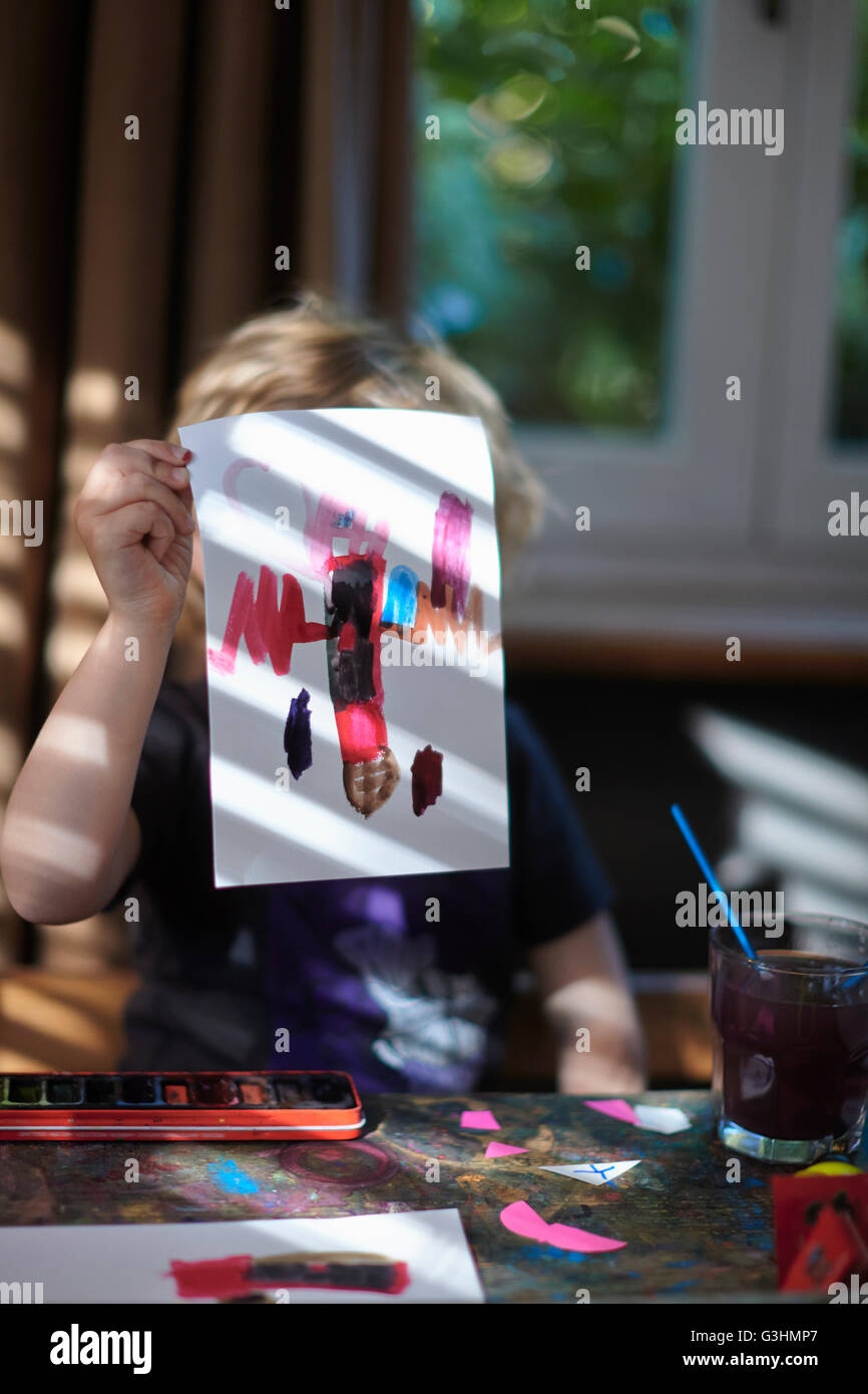 Porträt von Mädchen hält Malerei vor ihr Stockfoto