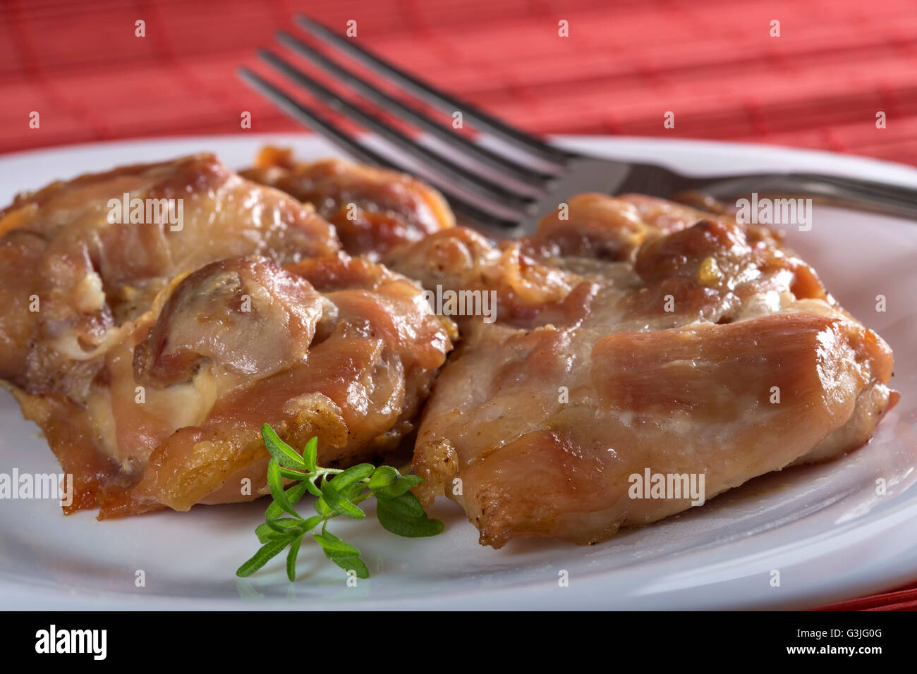 Hähnchenschenkel ohne Knochen Braten auf weißen Teller mit Gabel Stockfoto