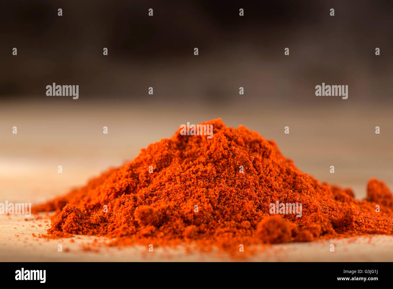 Rote heiße Paprika Pulver Heap auf hölzernen Hintergrund Stockfoto