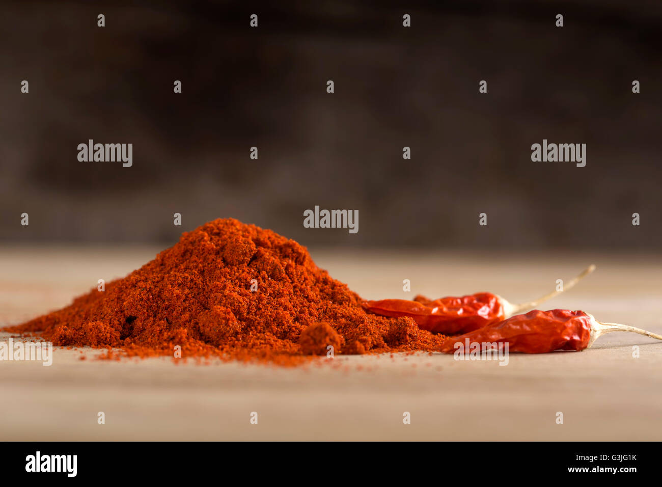 Red hot Chili peppers und Paprikapulver über hölzerne Hintergrund Stockfoto