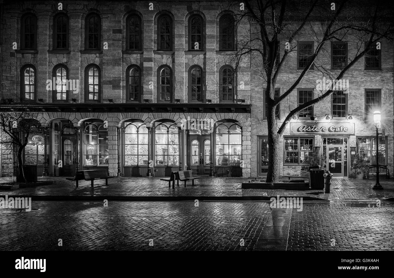 Stein und Ziegel Architektur entlang der Saint Anthony Main Street in Minneapolis, Minnesota in der Nacht nach Regenschauer. Stockfoto