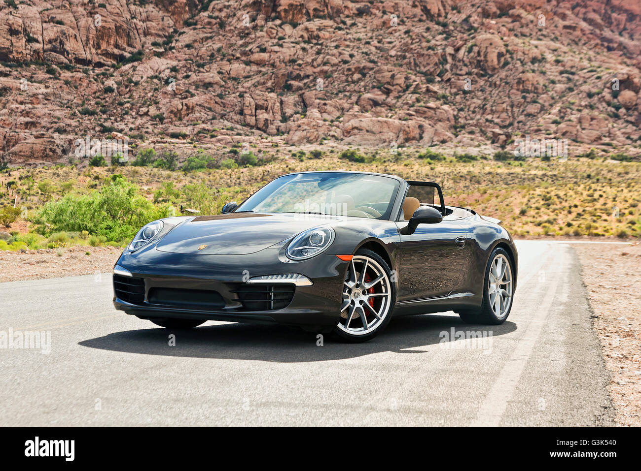 Vorderansicht eines Porsche 911 Carrera Autos auf einer einsamen Bergstraße Stockfoto