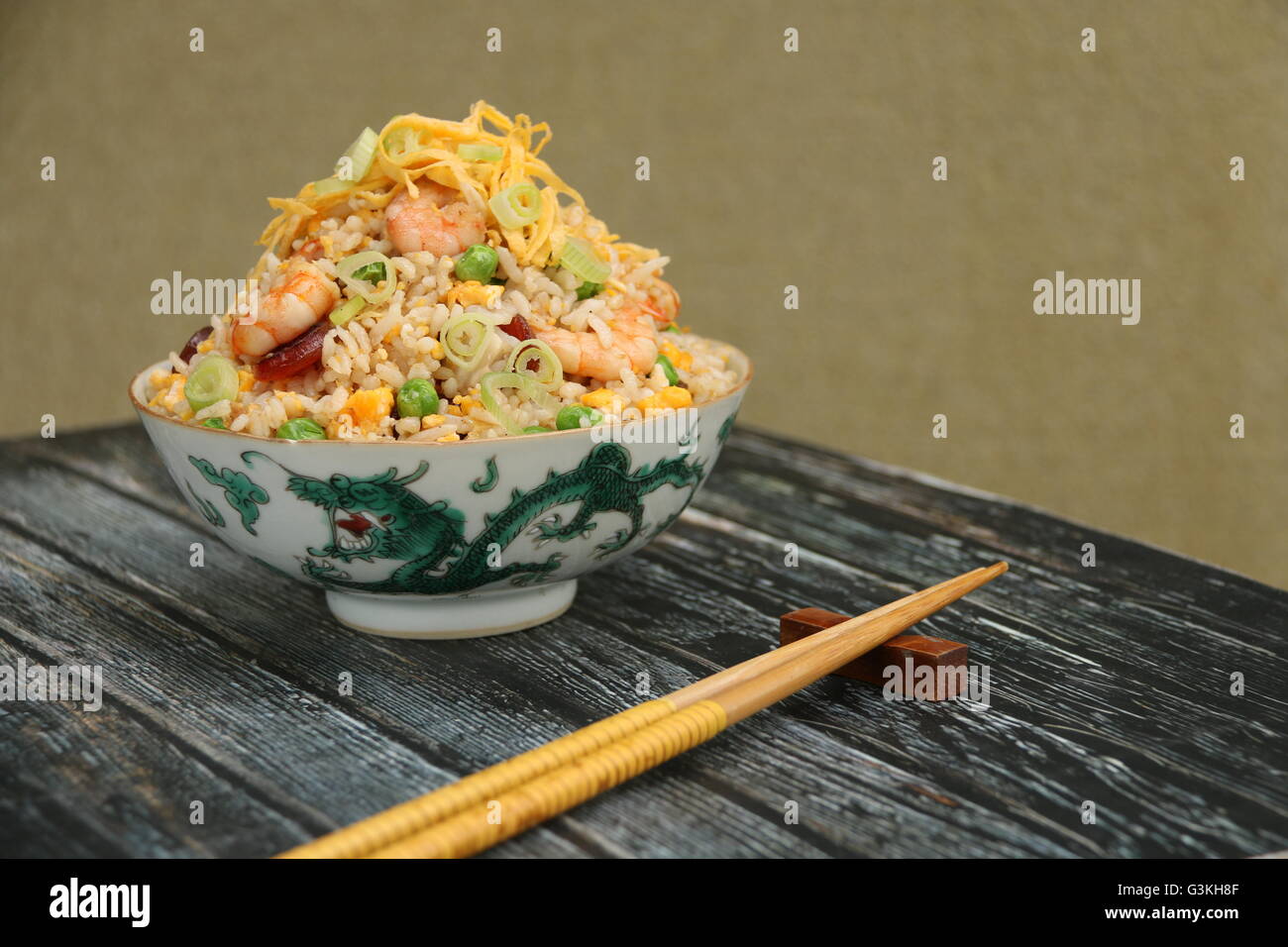 Chinesischer gebratener Reis mit Garnelen, Ei, Erbsen, Chinesisch Wurst und grüne Zwiebel gekocht. Auf Vintage chinesische Reisschüssel serviert. Stockfoto