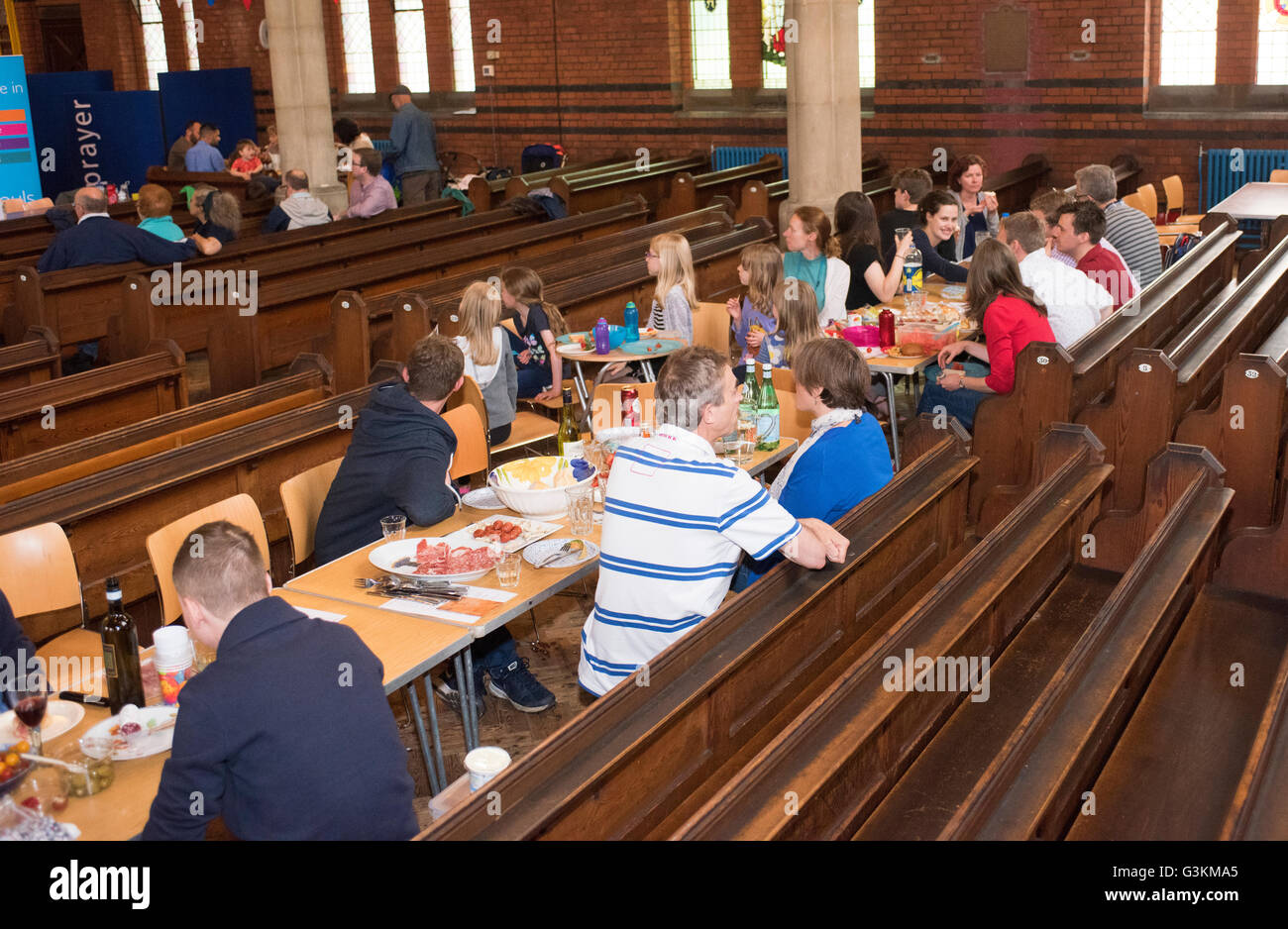 Regen bedeutete "The Big Lunch" im Inneren der Kirche zog. Bewohner in der Kirche, Essen Essen, Gemeinschaft Stockfoto