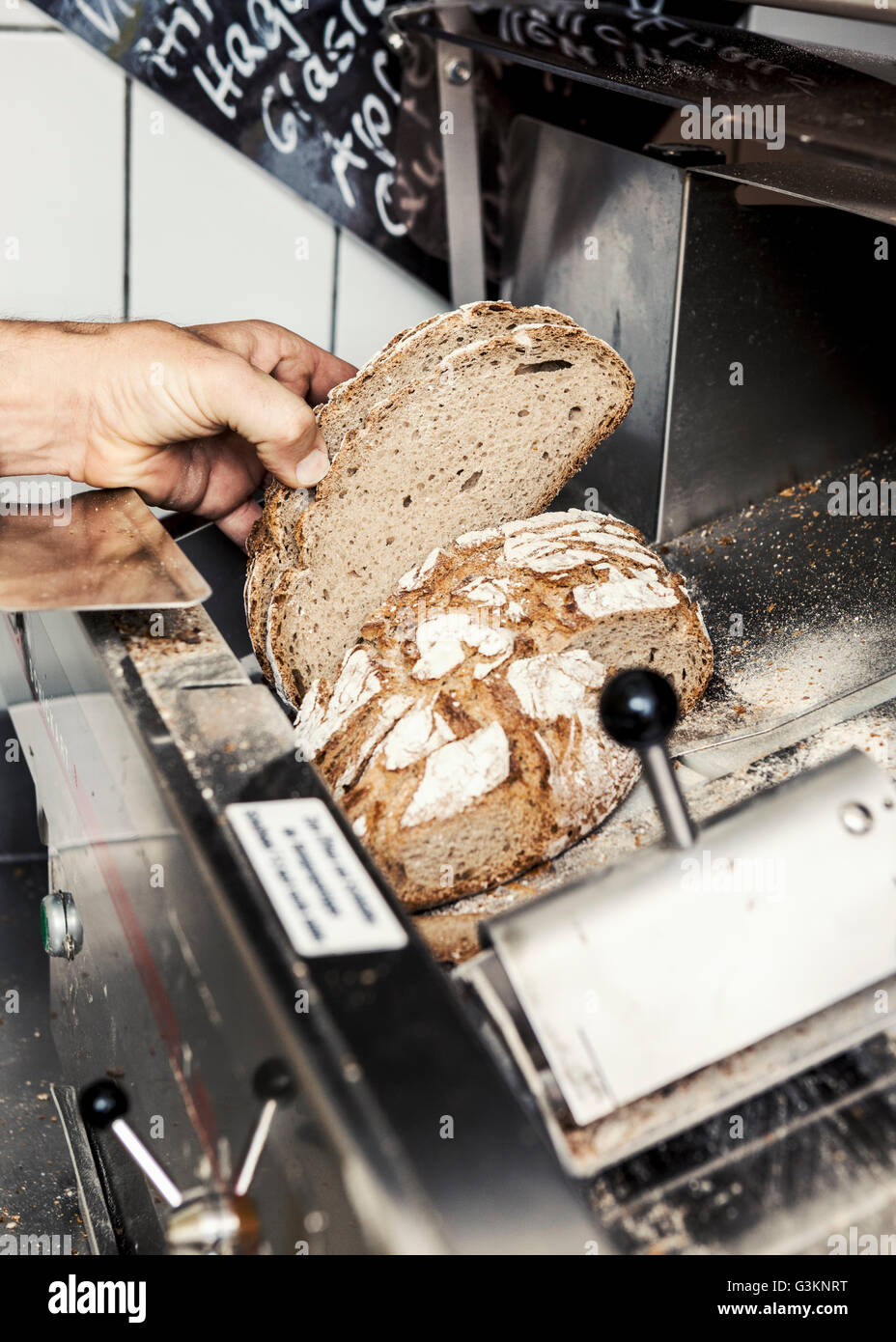 Bäcker mit einem Laib Brot in Scheiben geschnitten Stockfoto