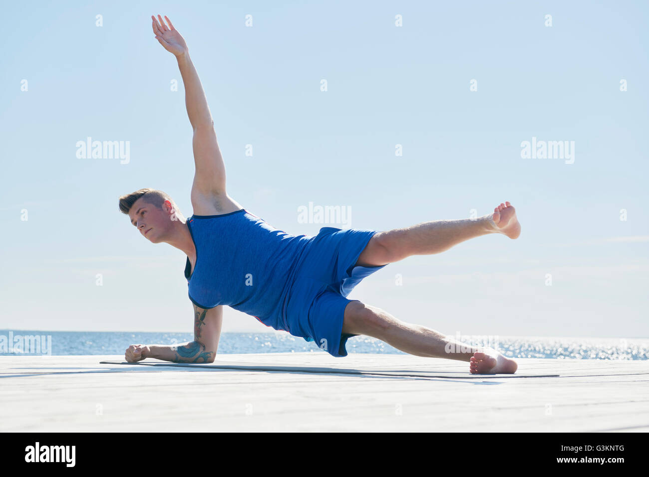Mann am Pier ruht auf Ellenbogen, arm angehoben tun Seite push-up Stockfoto