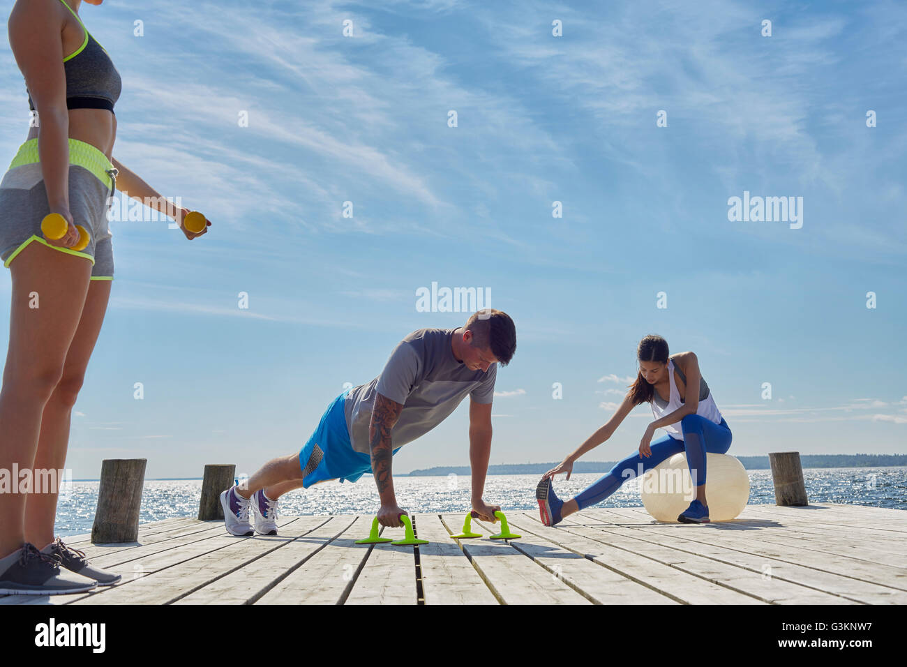 Freunde am Pier mit Trainingsgeräten Stockfoto