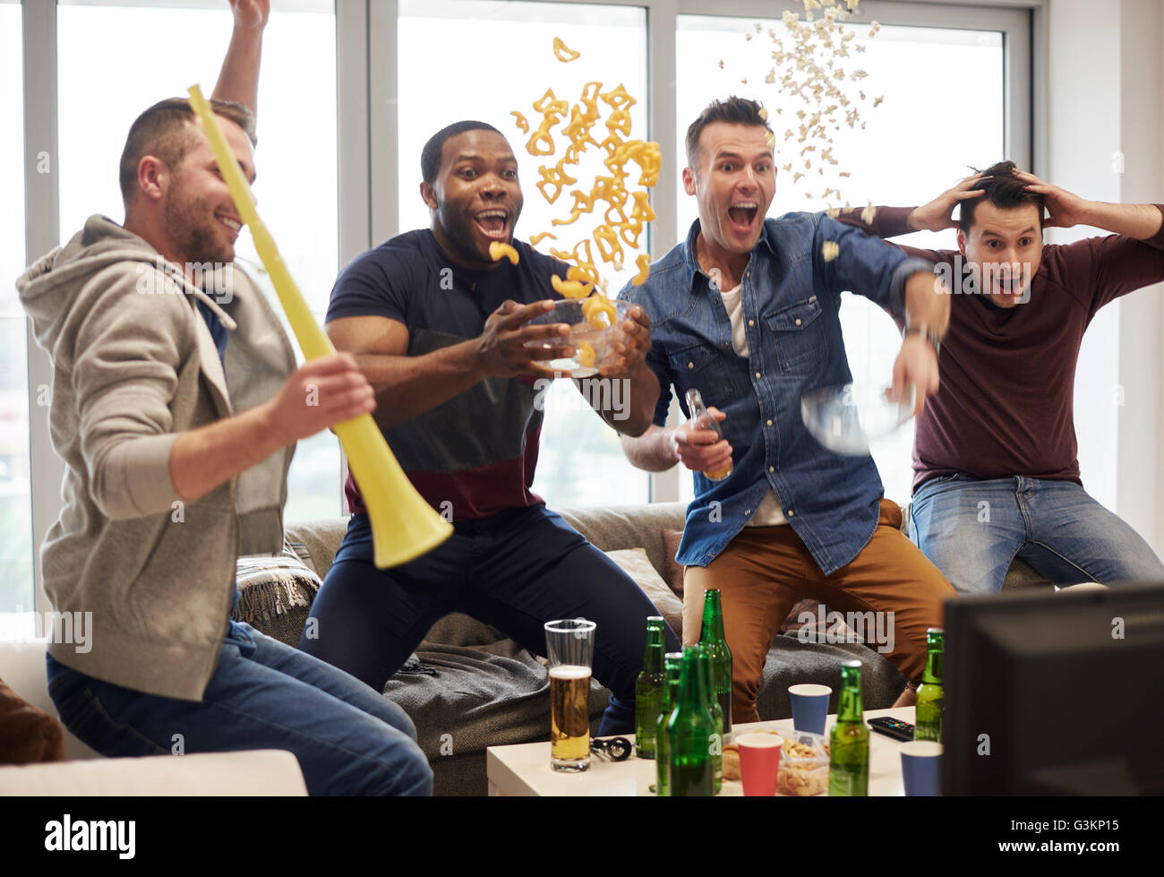 Gruppe von Männern beobachten Sportereignis im Fernsehen feiern Stockfoto