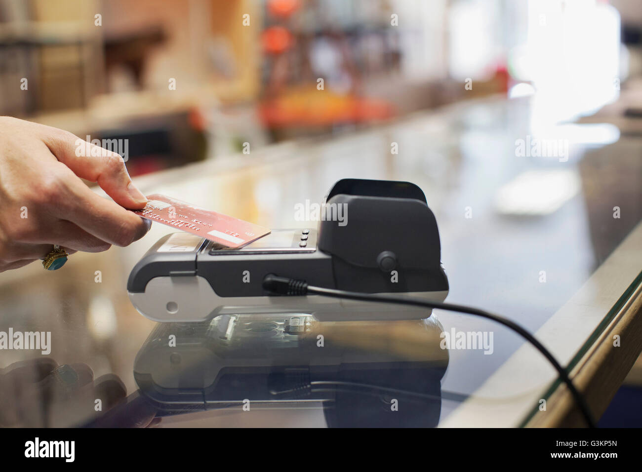 Zugeschnittenen Überblick Damen Hand mit Kreditkarte, kontaktloses Bezahlen auf Chip und Pin-Maschine zu machen Stockfoto