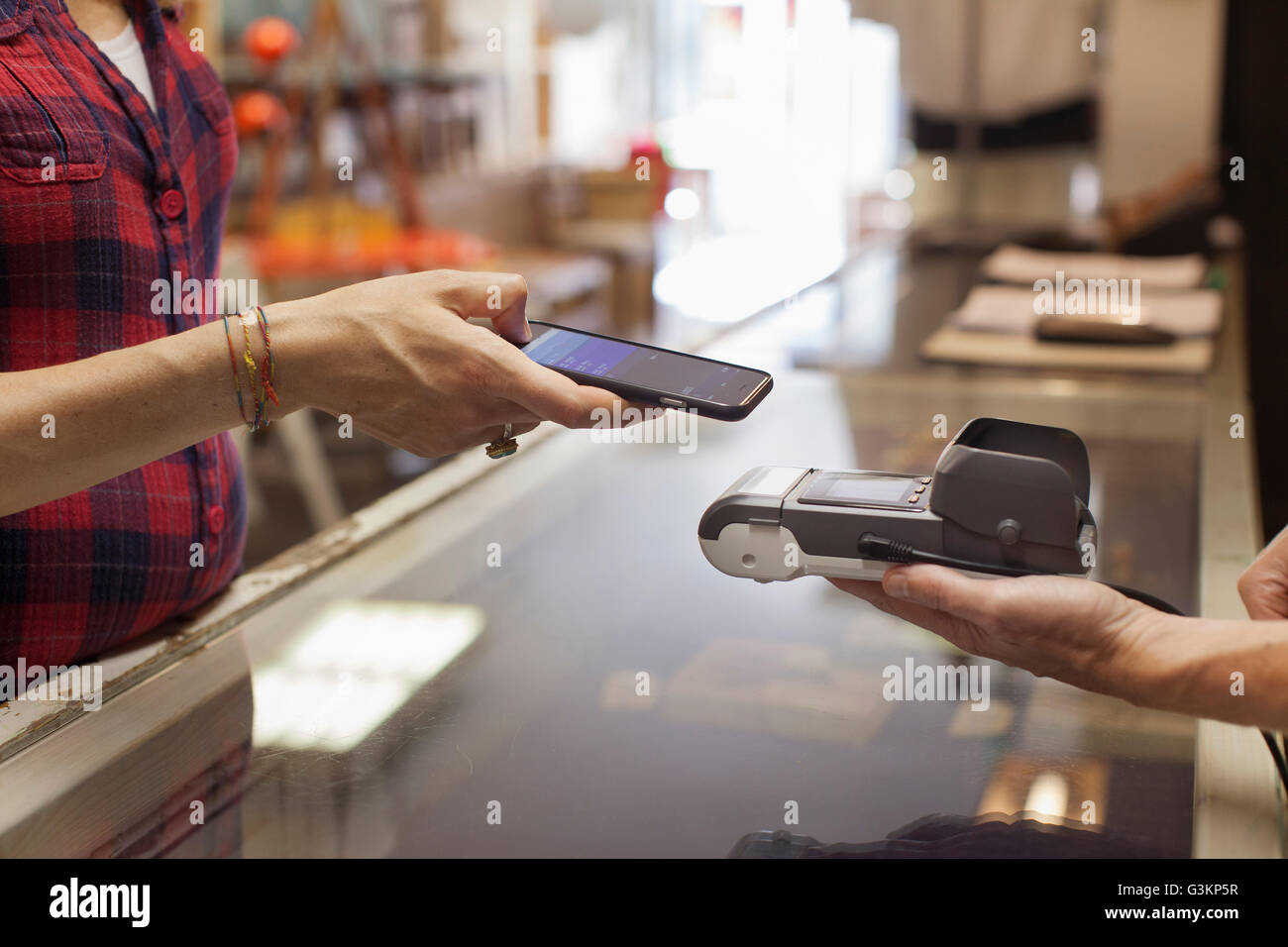 Ansicht der Womans Hände mit Smartphone für die kontaktlose Zahlung auf Smartphone zugeschnitten Stockfoto