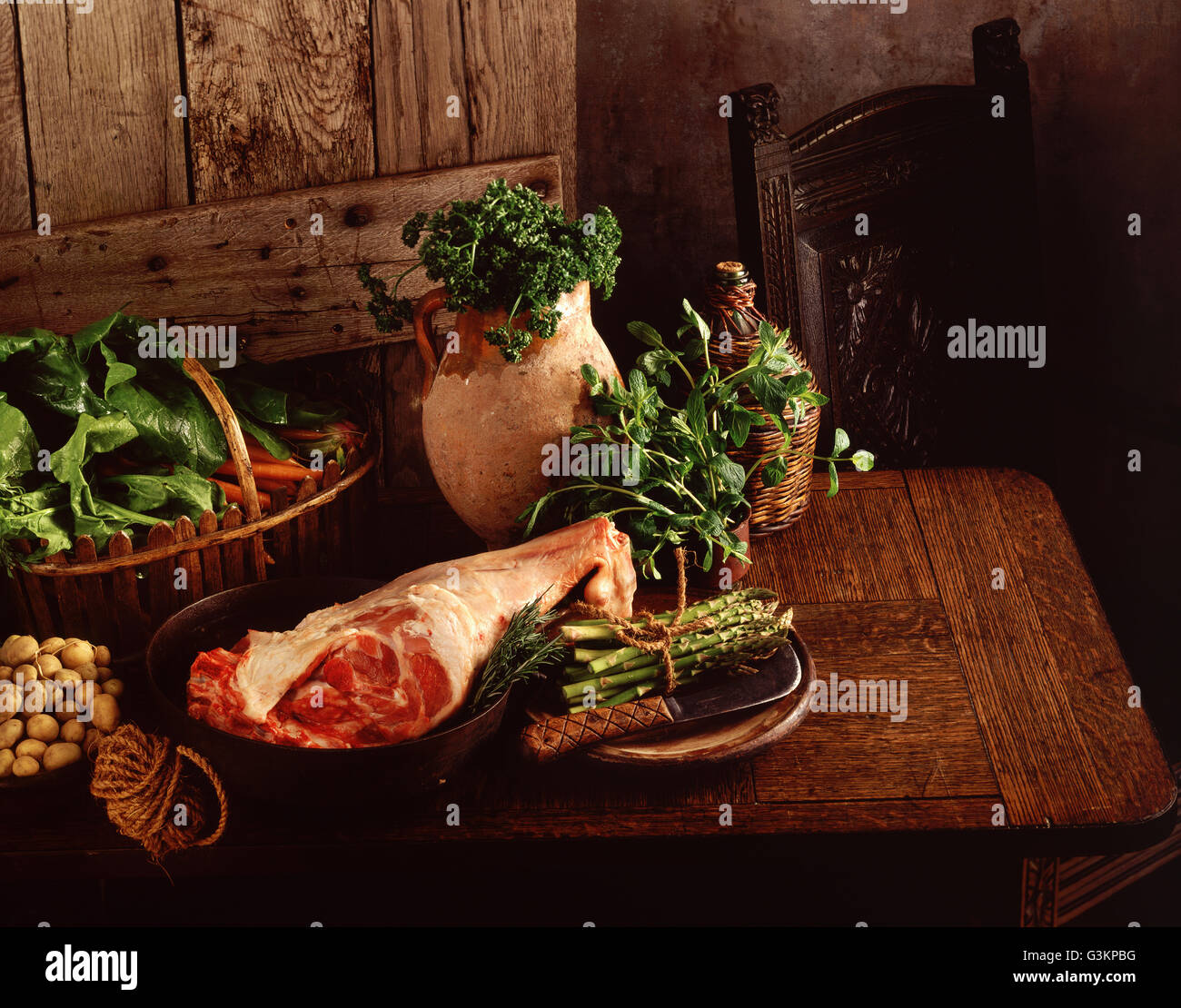 Rohe Bein des Lammes, neuen Kartoffeln, Spargel, Spinat, Karotten, Petersilie und Minze Stockfoto