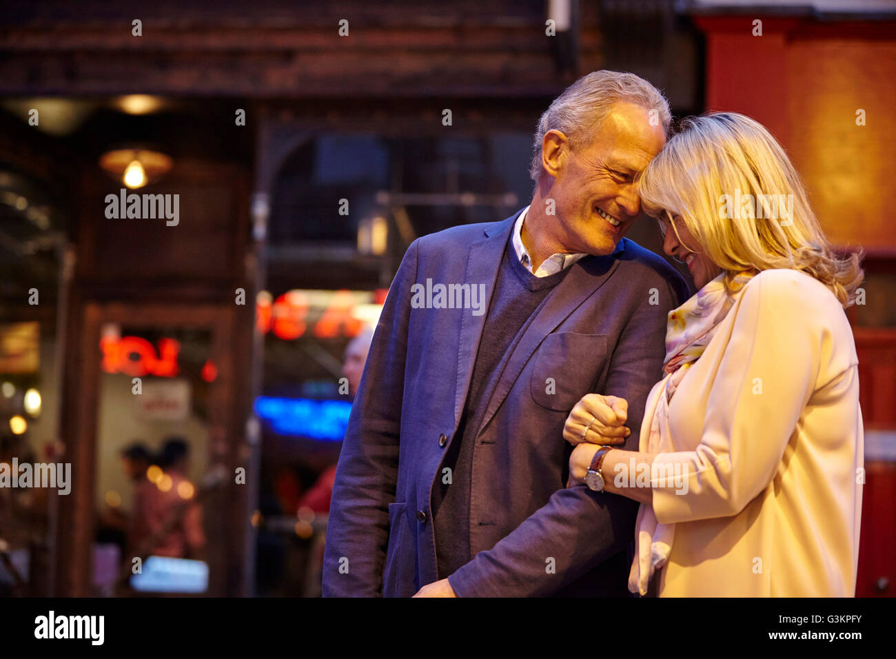 Reife dating paar Sarm im Arm auf Stadtstraße in der Nacht, London, UK Stockfoto