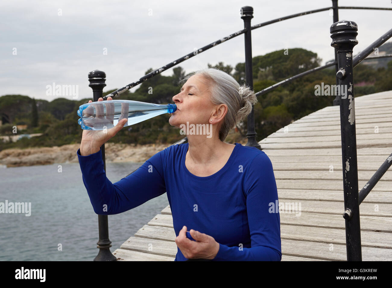 Reife Frau im Freien, trinken aus der Flasche Wasser Stockfoto